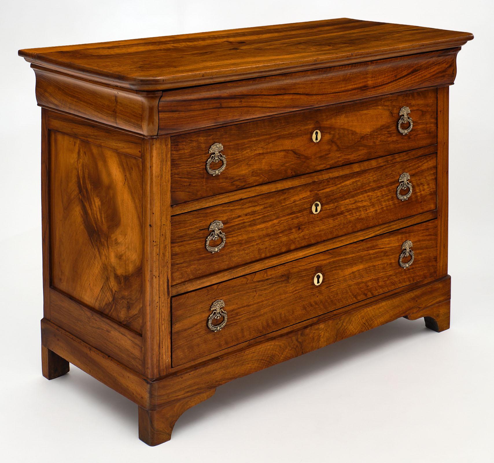 French antique figured walnut chest featuring four dovetailed drawers. This solid piece is from the Rhone Valley in France and has a beautiful, honey toned patina. It has been finished with a lustrous French polish and beeswax. We love the original