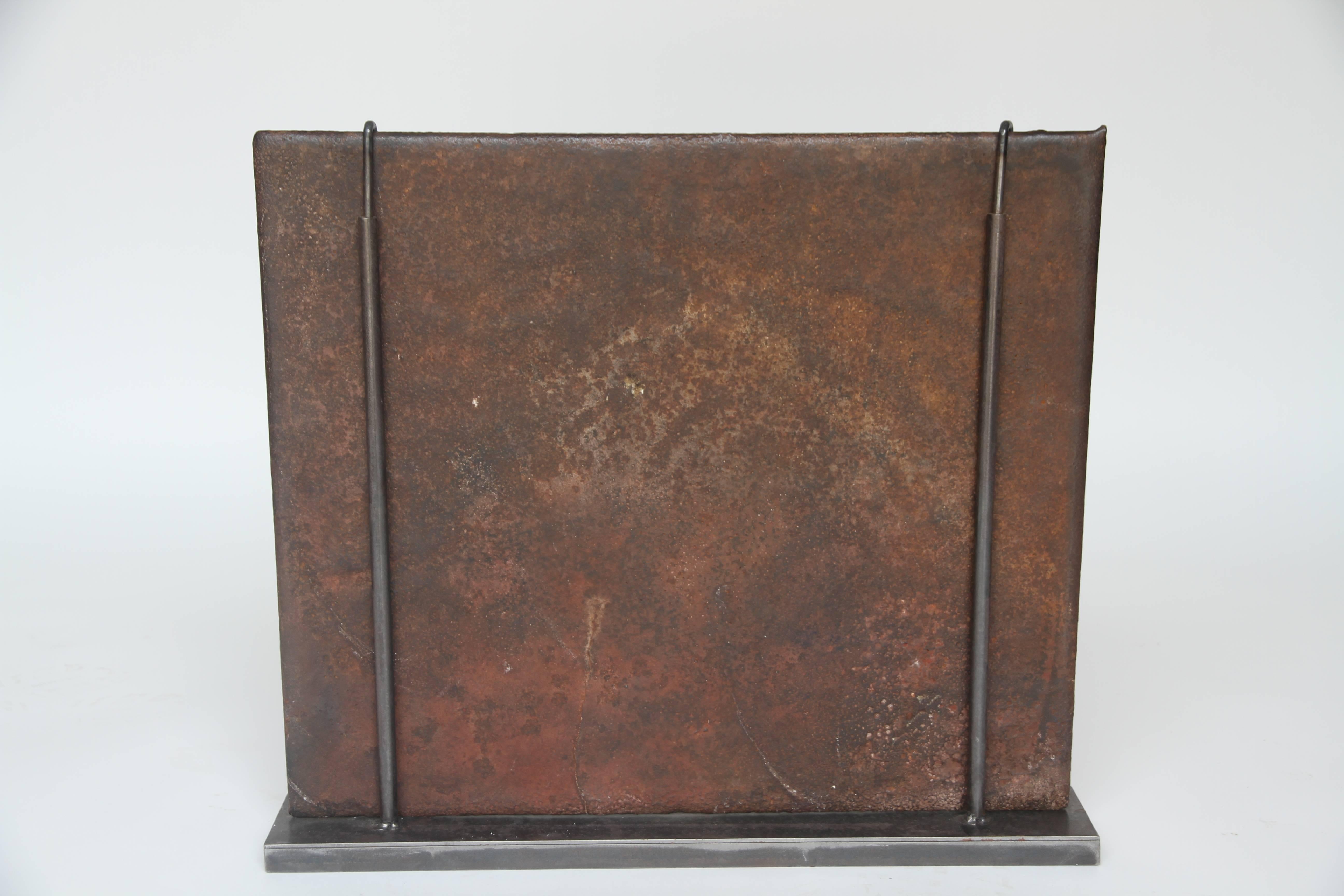 Antique French cast iron fireback, 19th century. This piece can be used, as its original use, in a fireplace or as a stove top backsplash. A custom stand is provided so the piece can stand alone as a decorative item.