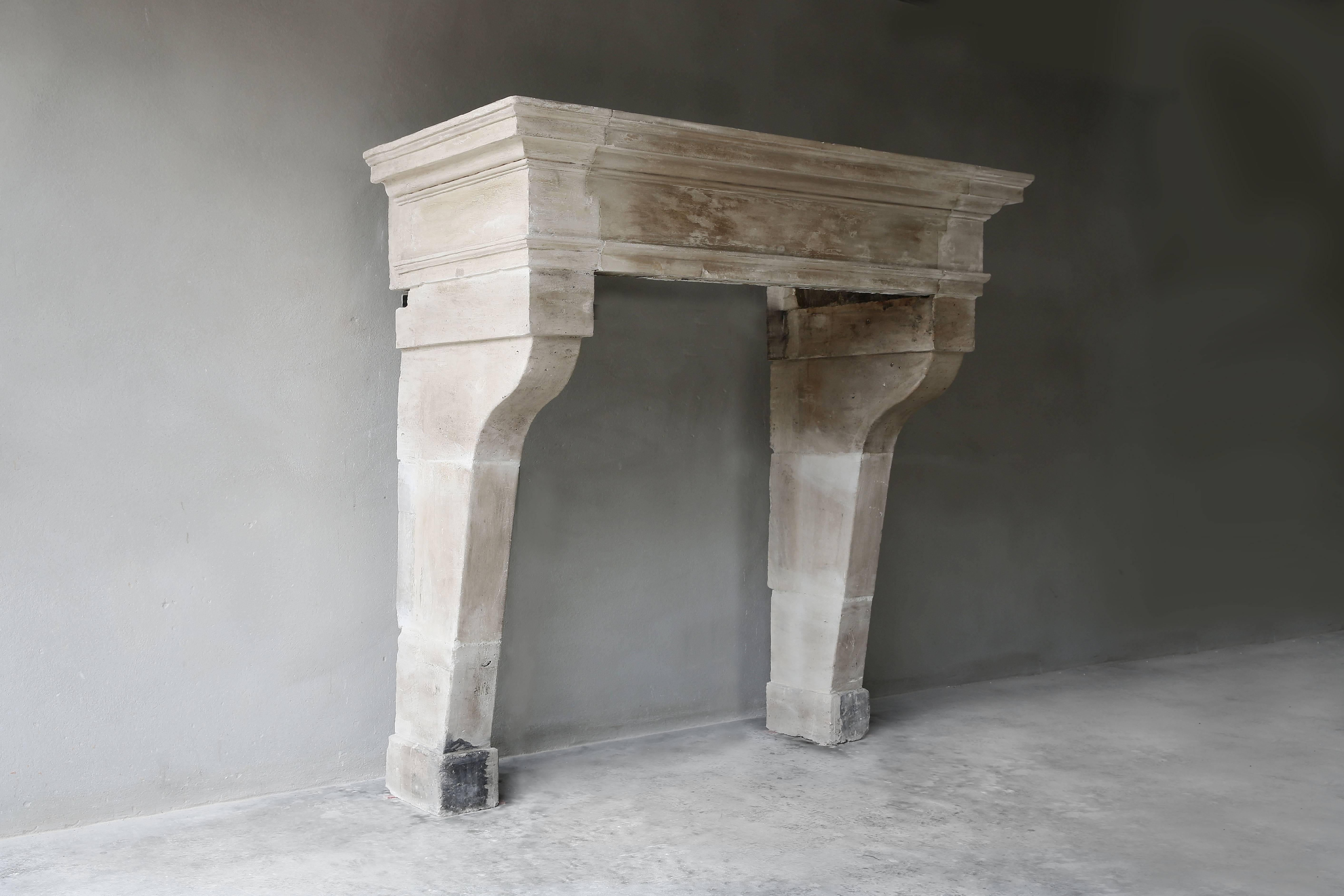 Very nice antique French fireplace of limestone from the 18th century in the style of Louis XIII. This fireplace has the right proportions and color tone and is very popular by its shape and soberness.