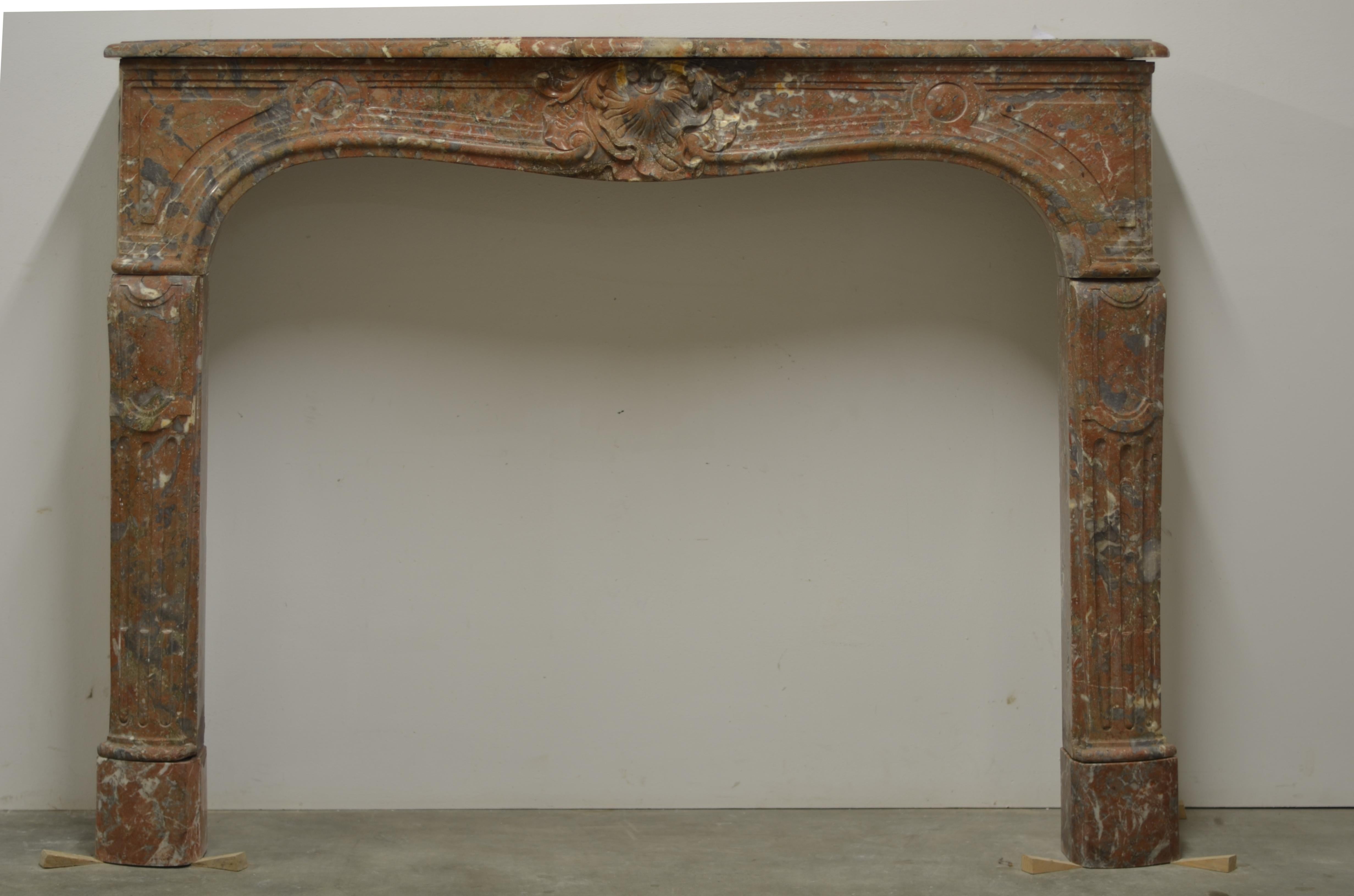 Amazing 18th century French Louis XV fireplace mantel.
This stylish mantelpiece is made from soft and subtle toned red marble wit nice and warm color variations.

The sides are not original but match nicely.
Great decorative and period
