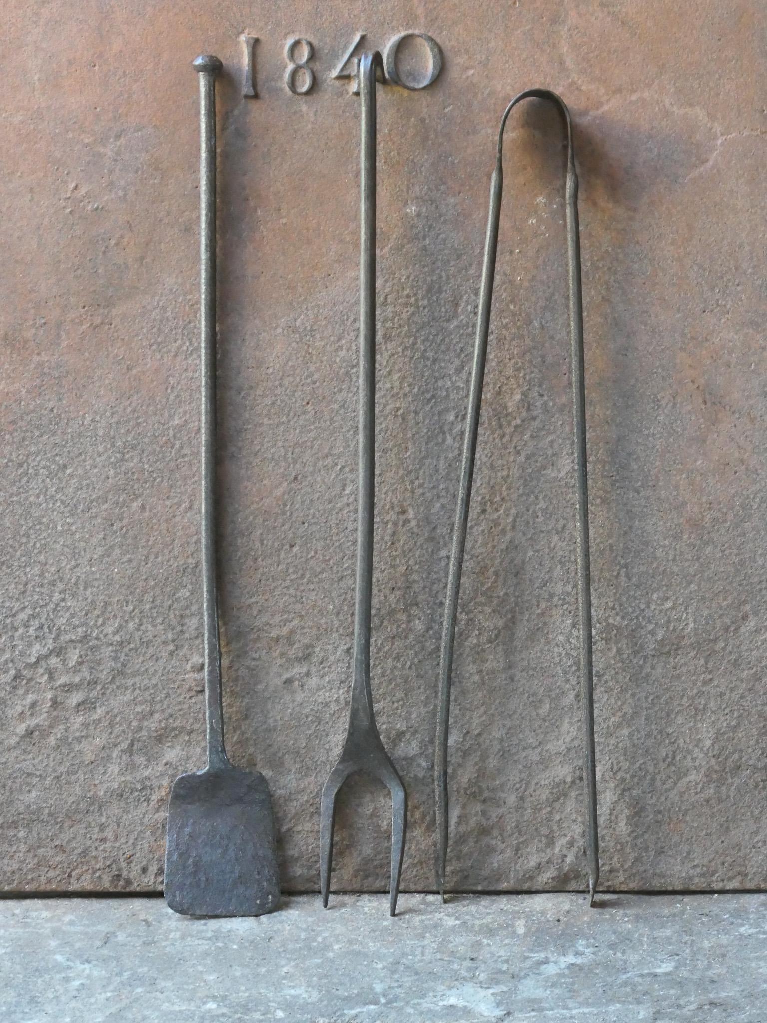 18th century French fireplace tool set. The tool set consists of tongs, shovel, and a fire fork. The tools are made of wrought iron. The set is in a good condition and fit for use in the fireplace.