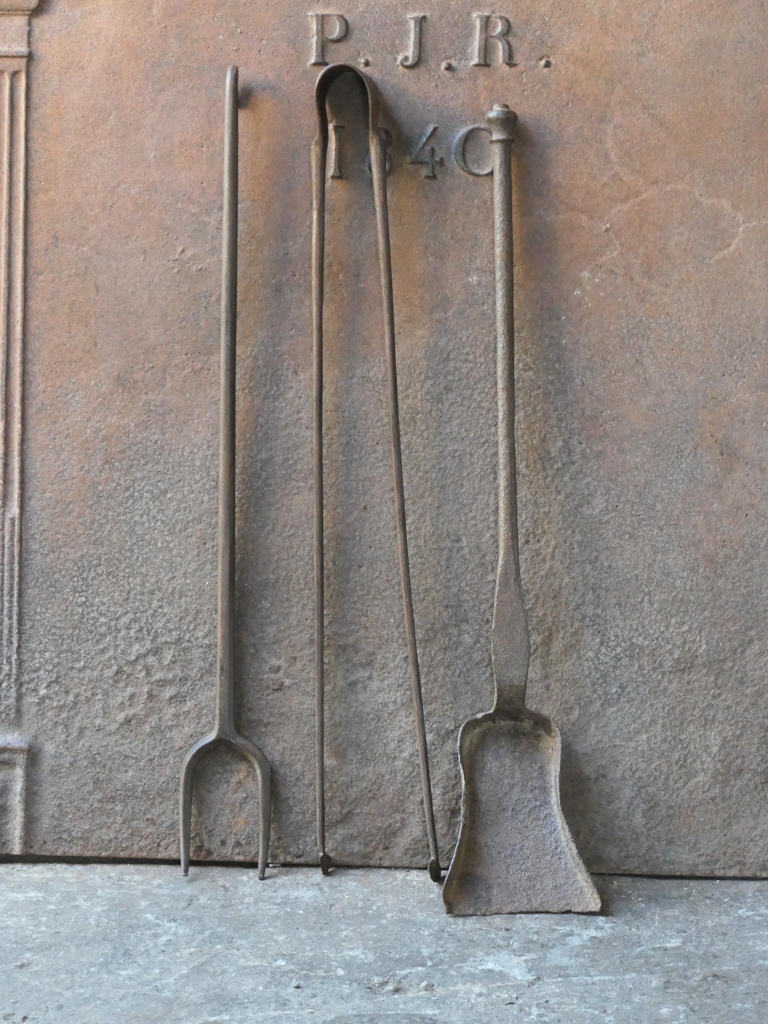 18th century French fireplace tool set. The tool set consists of tongs, shovel, and a fire fork. The tools are made of wrought iron. The set is in a good condition and fit for use in the fireplace.