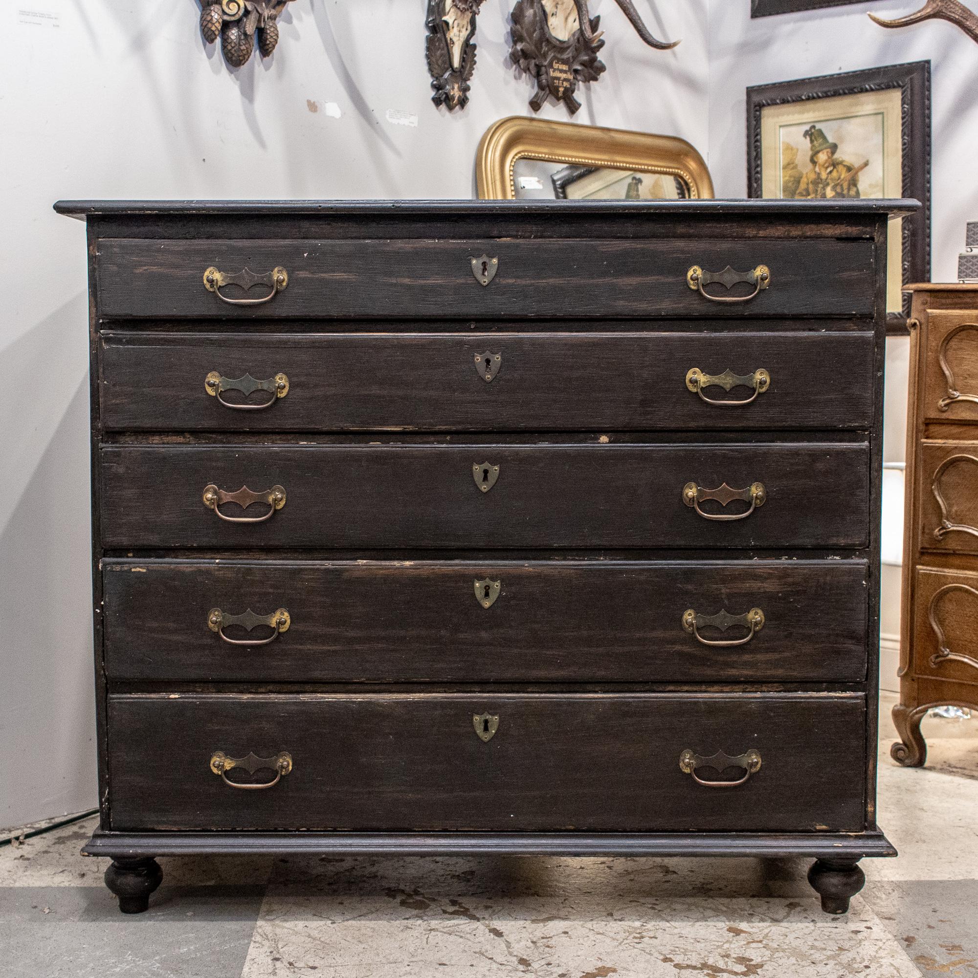 This antique French chest of drawers features a wonderful, distressed black painted finish. The color is almost an espresso or chocolate brown in artificial lighting, and more cool-toned black in natural light. You can see some of the wood finish