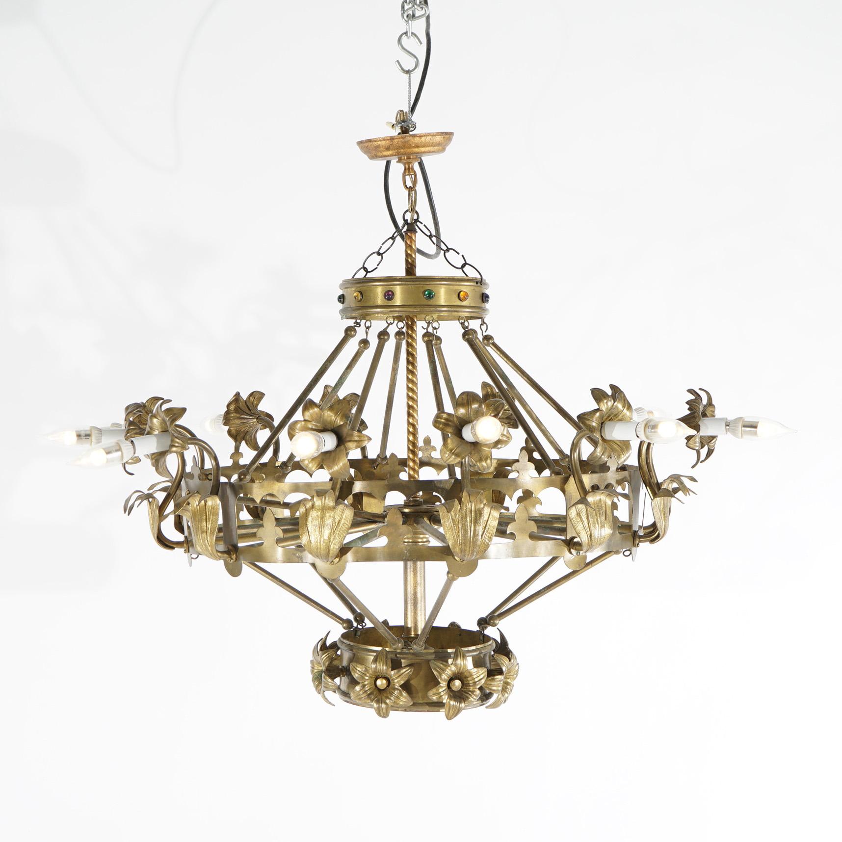 An antique French style chandelier offers brass frame in Fleur-de-Lis form having twelve floral form arms terminating in candle lights, jeweled accents, and rope twist drops, c1930

Measures- 32''H x 41''W x 41''D