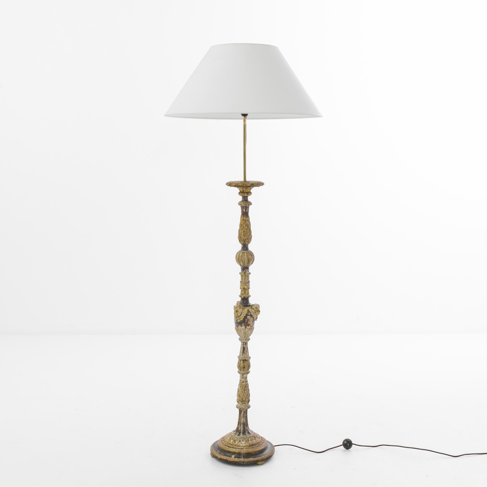 Made in France, circa 1800, this wooden floor lamp lends an old-world charm with the ornate carvings, adorned with polychrome color. Carvings of flowers and leaves impart a neoclassical touch. The white empire lampshade, supported by a slender brass
