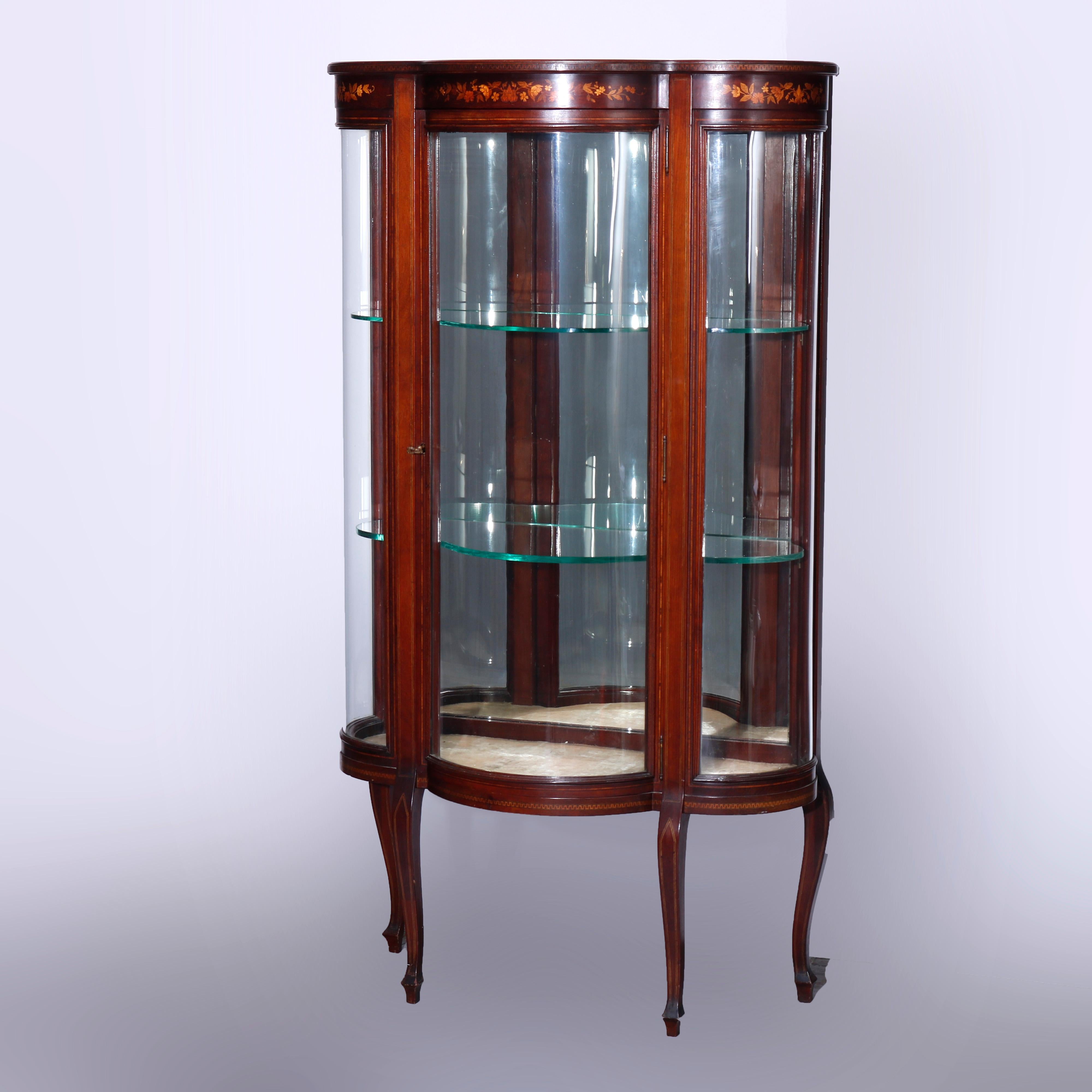 An antique French vitrine offers mahogany construction in clover leaf form with floral satinwood marquetry frieze over single curved glass door opening to shelved mirror back interior, raised on cabriole legs, satinwood banding and Greek Key