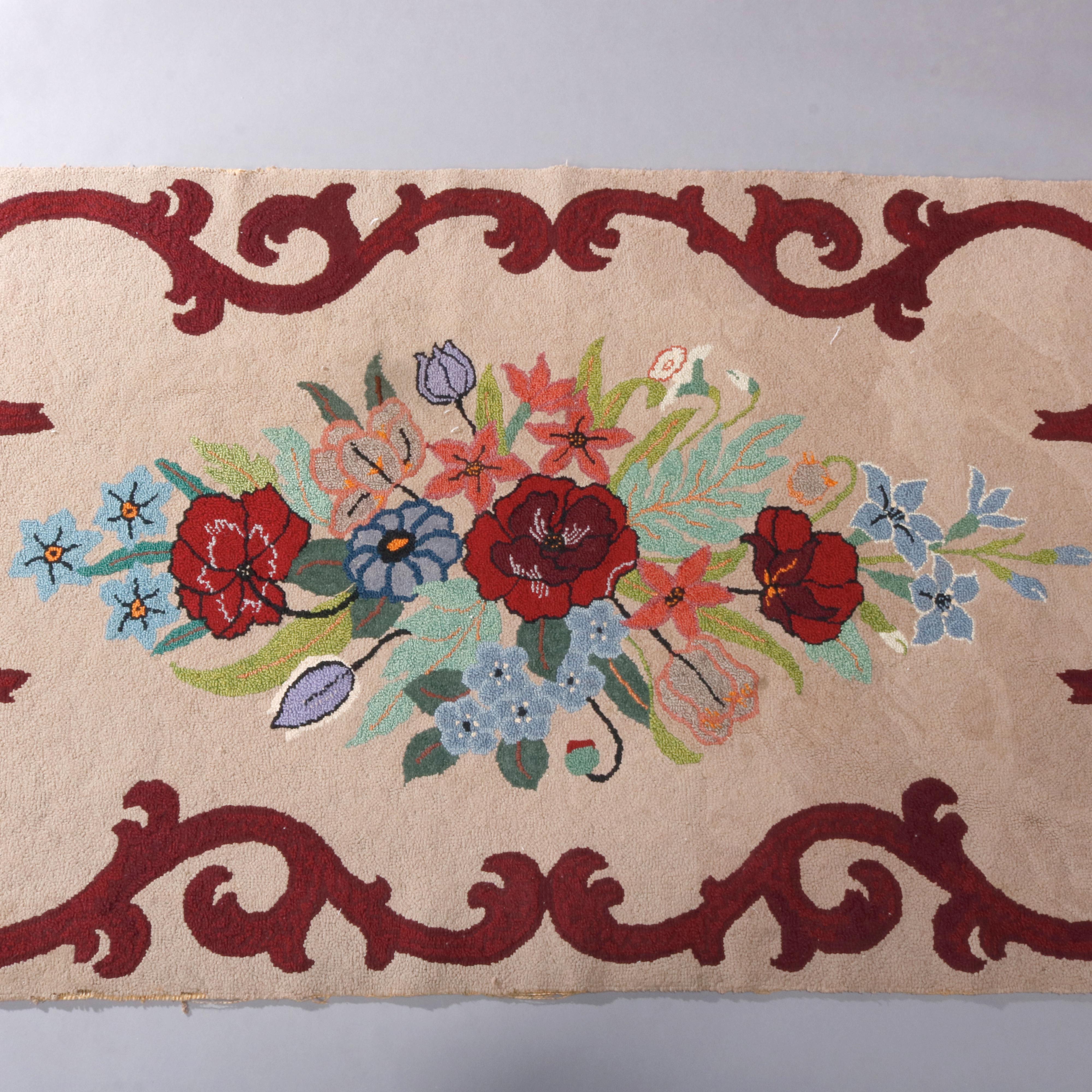 An antique French hooked rug offers central floral reserve with scroll and foliate border, circa 1930

Measures: 53