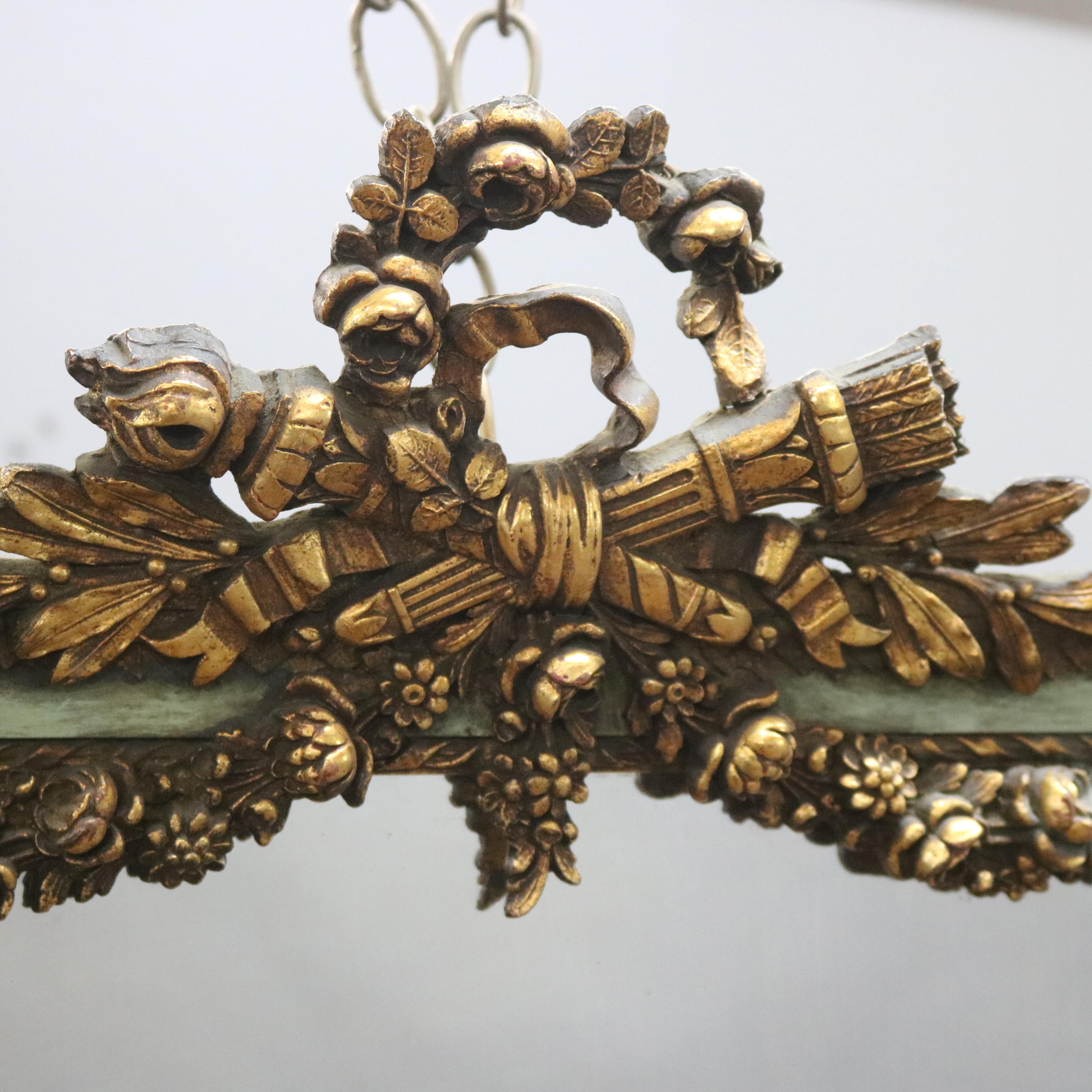An antique French wall mirror offers giltwood frame with pierced floral wreath crest and swags, 19th century

***DELIVERY NOTICE – Due to COVID-19 we are employing NO-CONTACT PRACTICES in the transfer of purchased items. Additionally, for those who