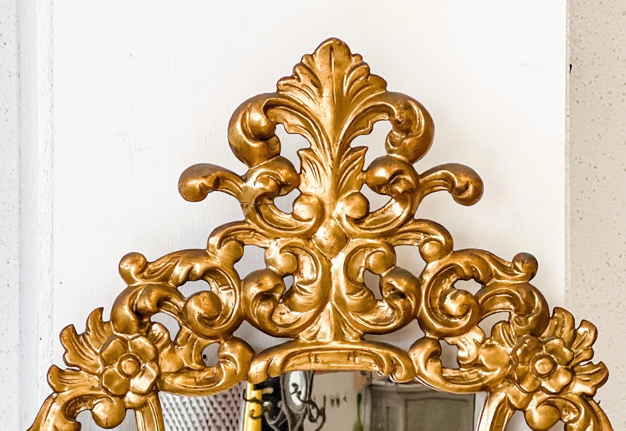 Antique French mirror with lovely floral gold gilt detail discovered in France. Carved and scrolled floral detail and backed in wood, this piece would be stunning as an accent mirror anywhere or in a powder room. Measures 33.8” in height and 20.5”