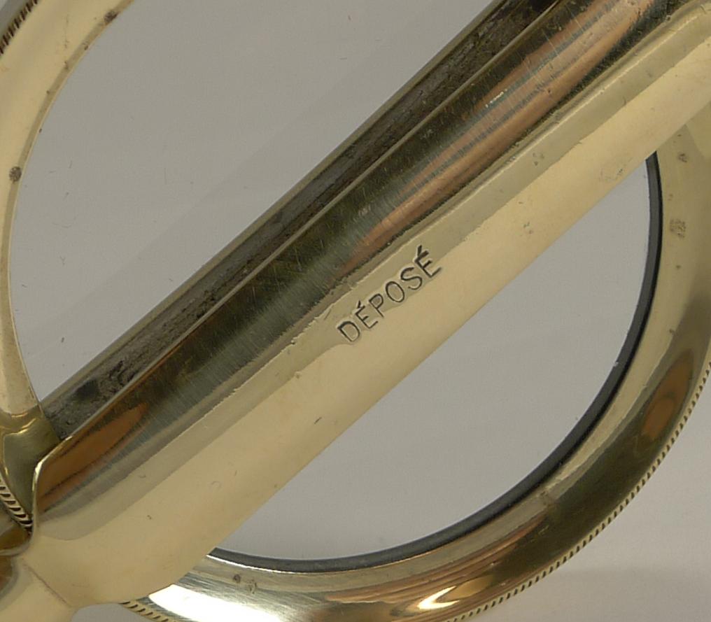 Always highly sought-after, this is a large example of a French folding magnifying glass, the handle folding up and over the lens.

The glass is clear, with a good magnification. The handle is engraved 