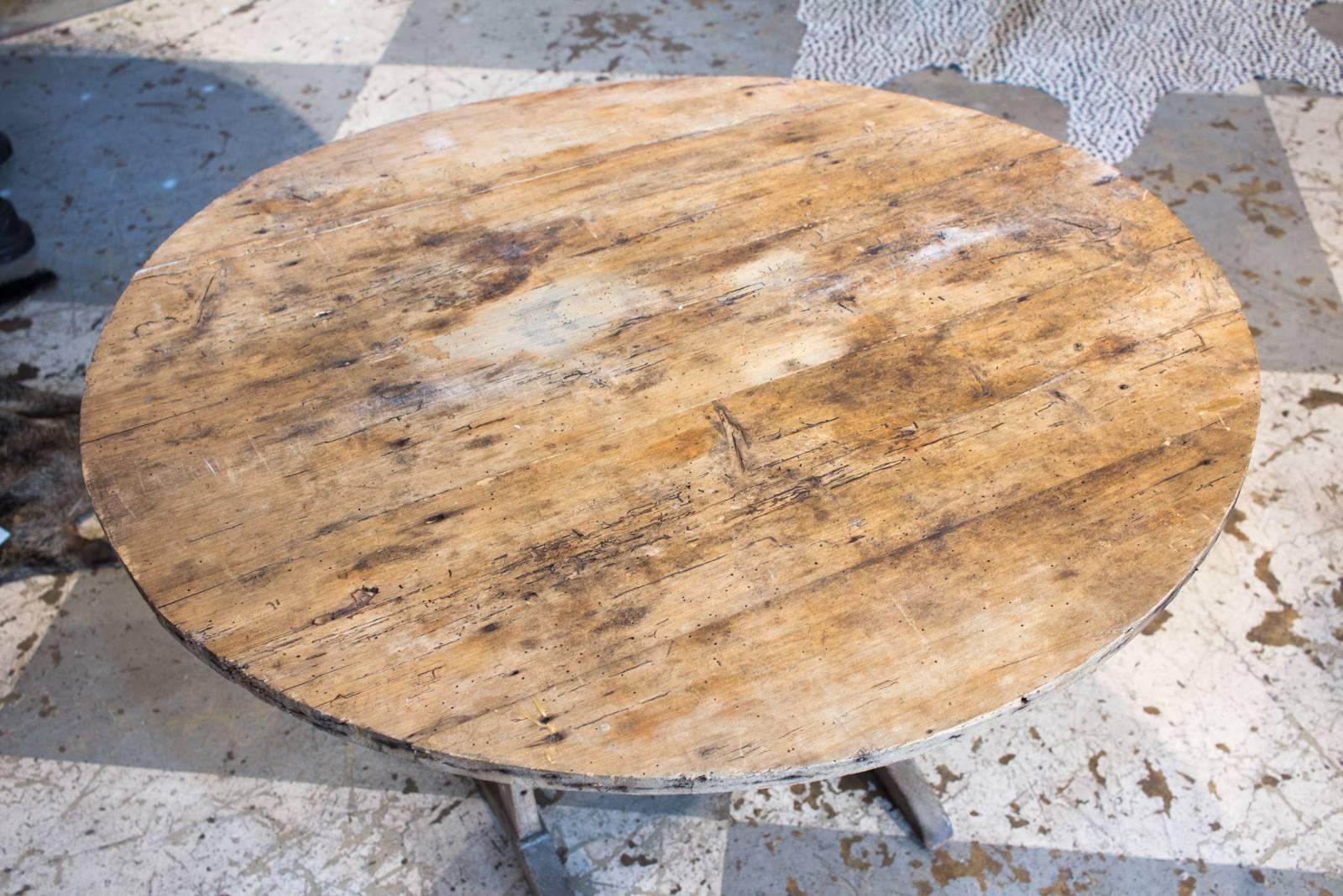 This is a classic French wine table we sourced on our last trip to Northern France. This piece is solid wood and dates to circa 1910. The top can be swivelled down for use or up when kept aside when not in use. Top is distressed, but when put flat,