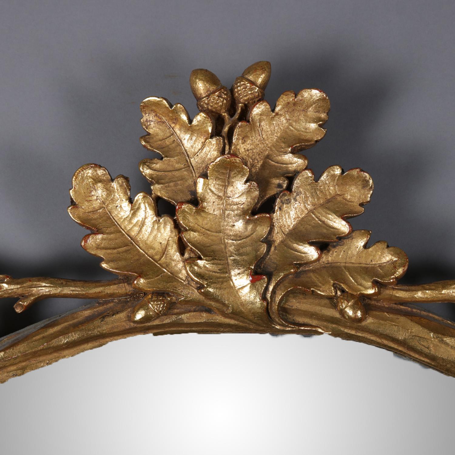 An antique French giltwood wall mirror features reticulated twig, acorn and leaf form frame with oak leaf crest, 19th century.

Measures: frame 44