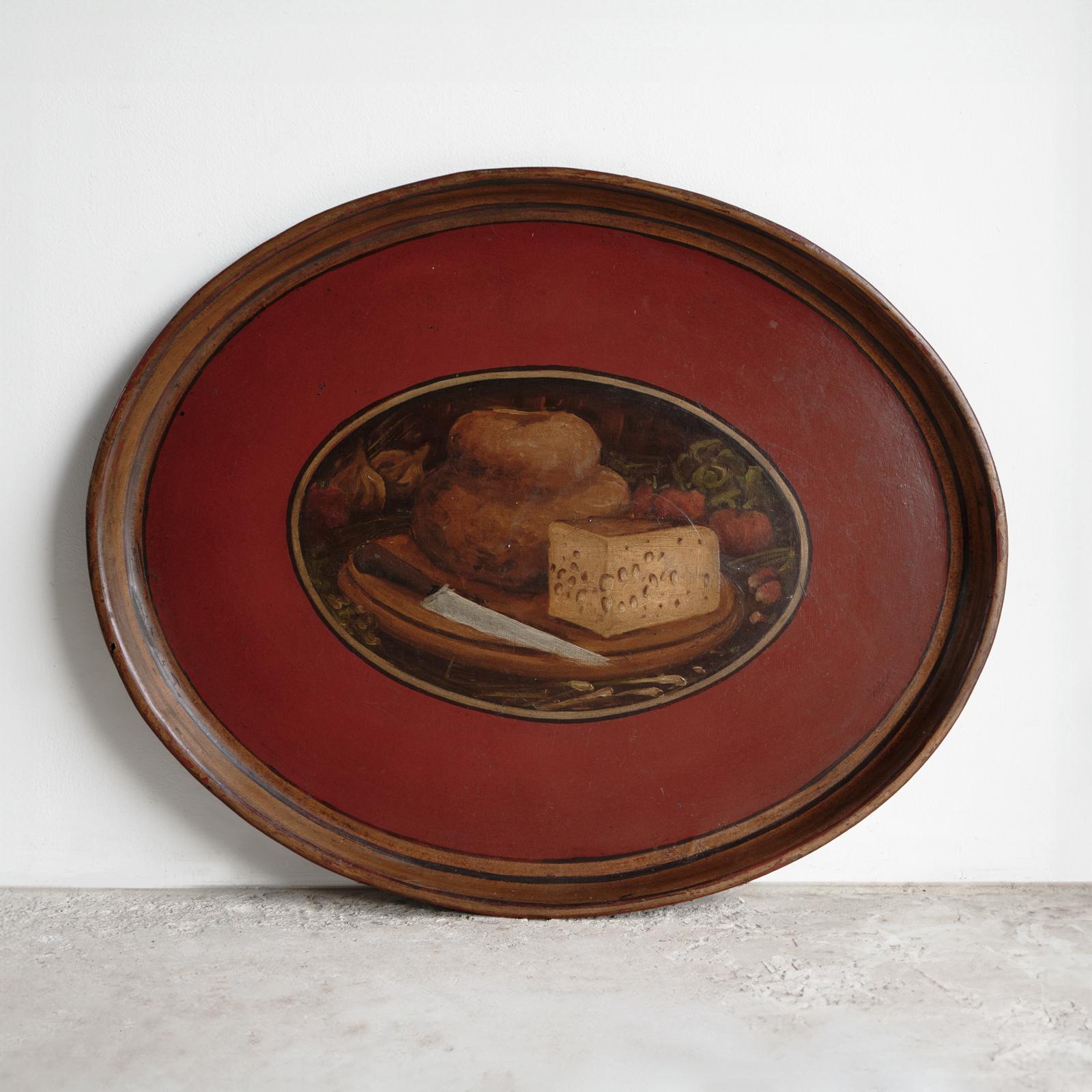 Antique Tole Peinte Tray

A very usable oval tray made of tin with hand-painted decoration with a central panel depicting a wooden chopping board and knife with a rustic round loaf of bread with a wedge of holey Swiss-type cheese surrounded by figs,