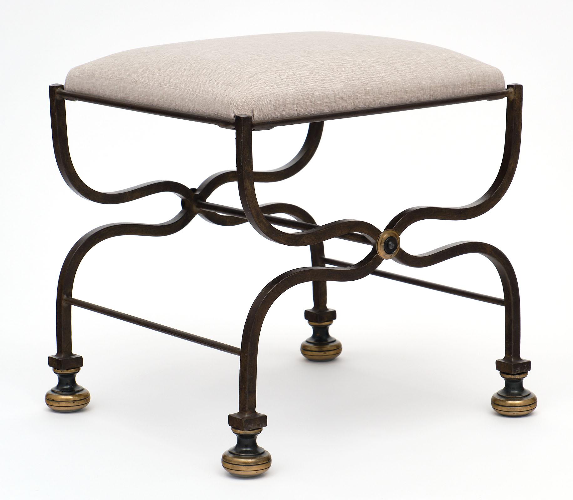 French antique forged iron bench with a strong design. This hand-hammered piece has bronze bun feet and detailing. The top cushion has been newly upholstered. There is a pair of matching chairs as well.
