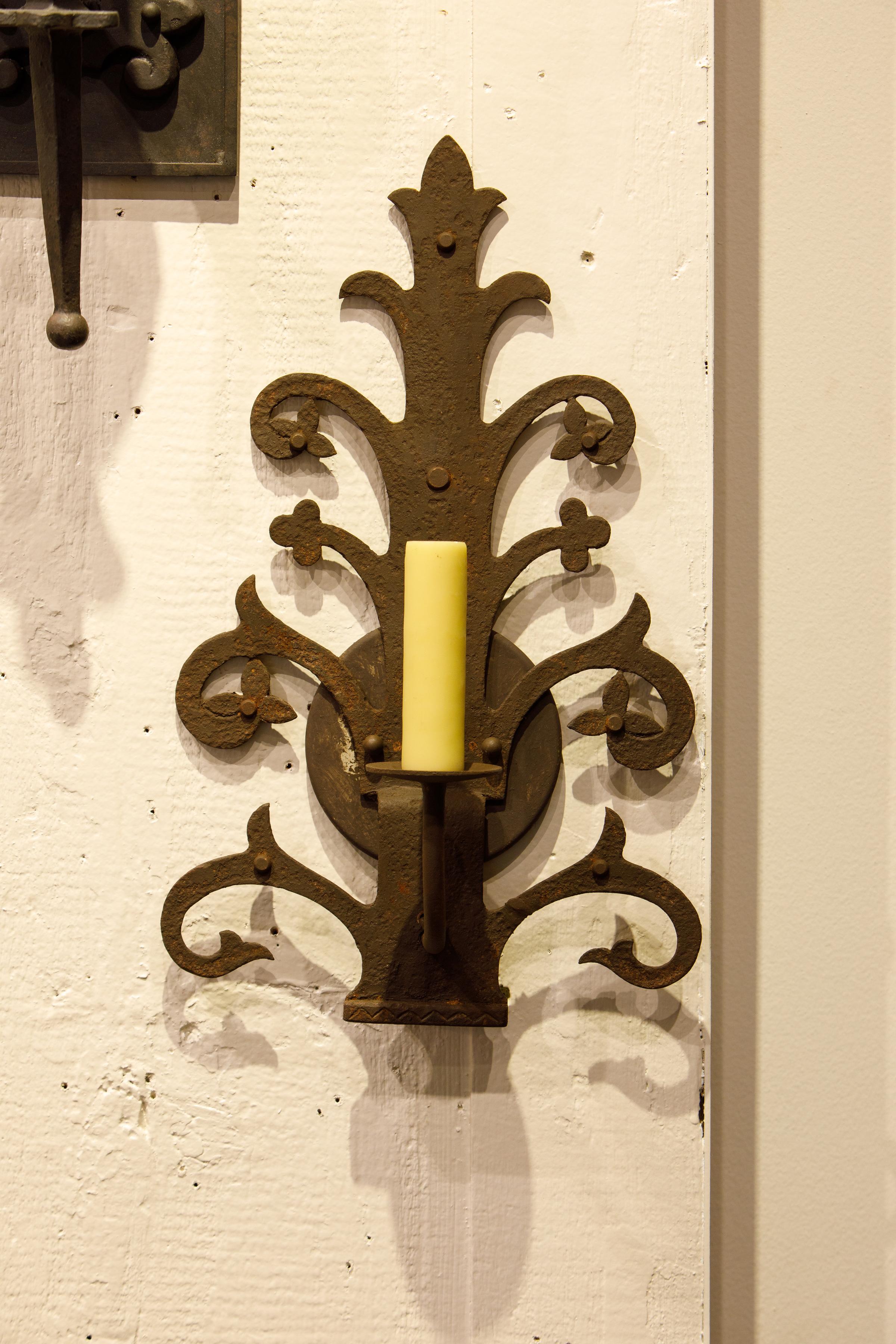 We have a pair of these sconces available. They are hard to classify stylistically because they have elements of both French Rustic and Spanish Colonial styles. Beautifully forged iron in and interesting flower-like motif. Re-wired for US with all