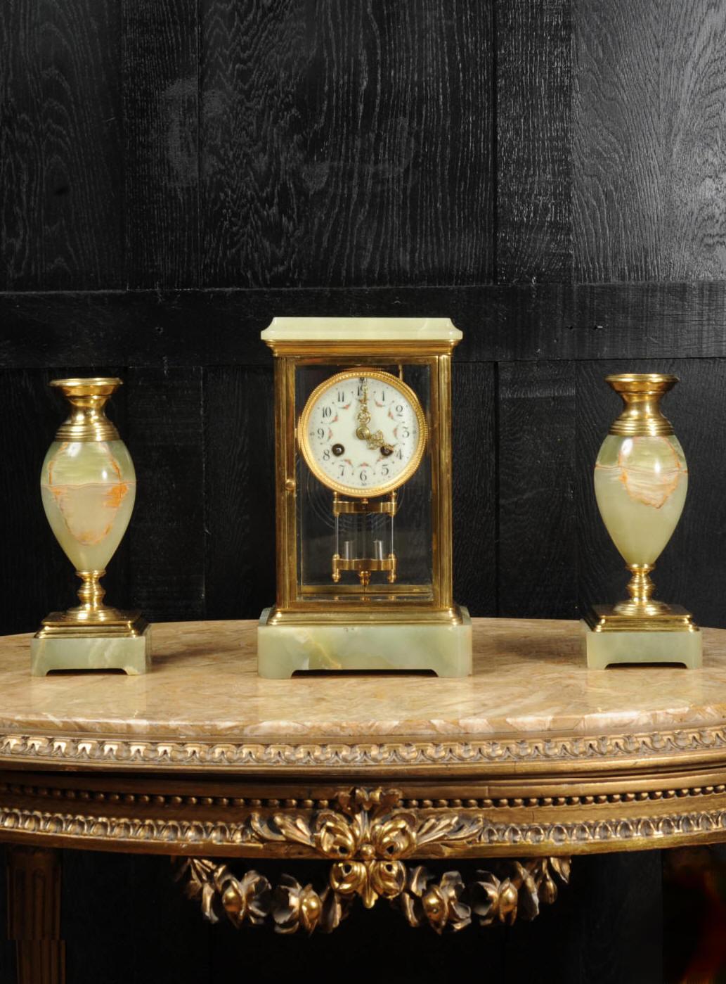 A superb and chic antique French four glass regulator. It features a mercury compensated pendulum gently swinging behind beveled glass in four sides. The case is constructed of a beautifully variegated onyx, mounted with ormolu and is classical in