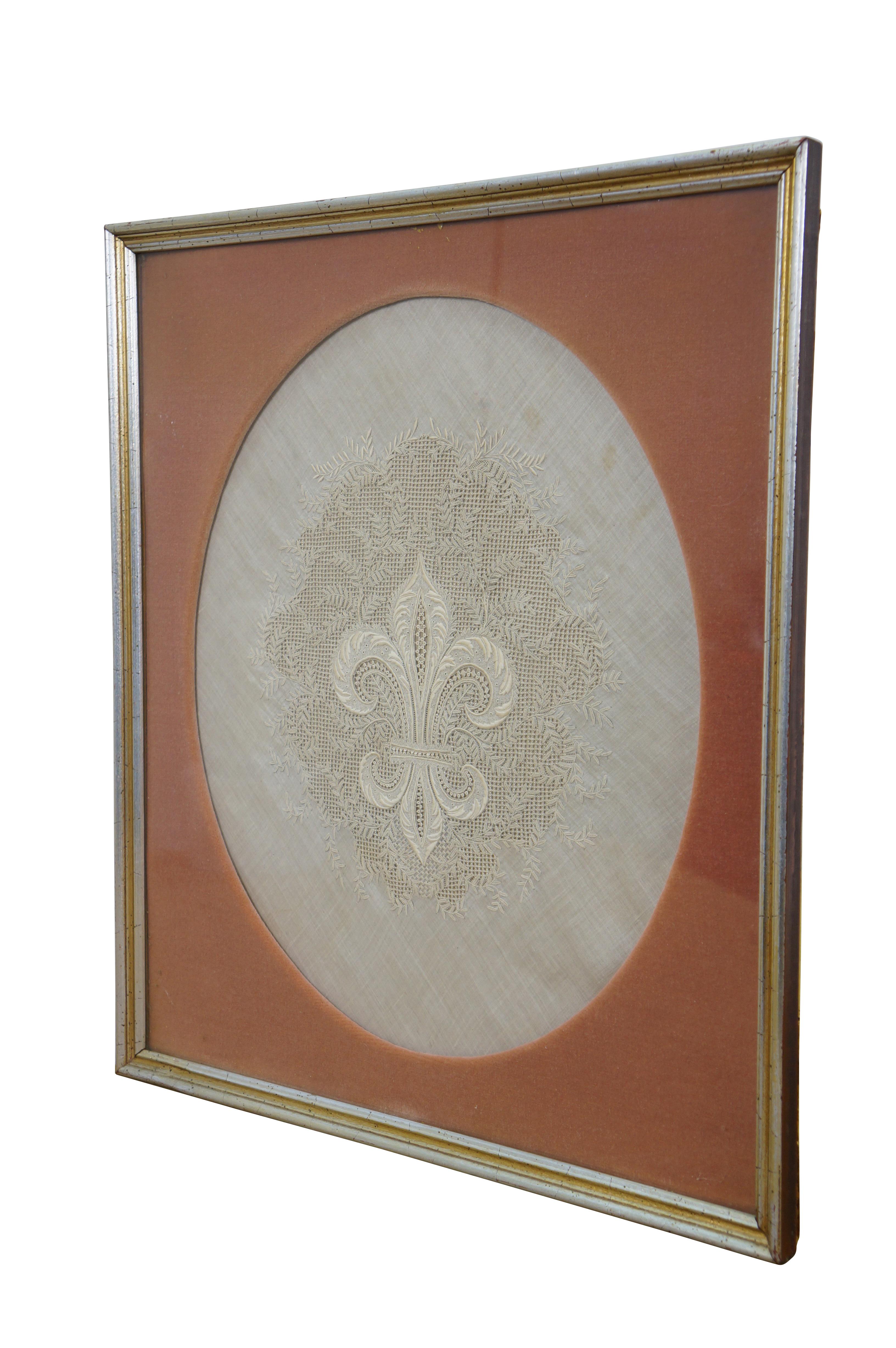 Antikes, gerahmtes Stück mit komplizierter Spitze und Stickerei auf weißem Leinen, das eine französische Fleur de Lis, umgeben von wirbelnden Blättern, darstellt. Silberner und goldener, abgeschrägter Holzrahmen; Matte aus orangefarbenem
