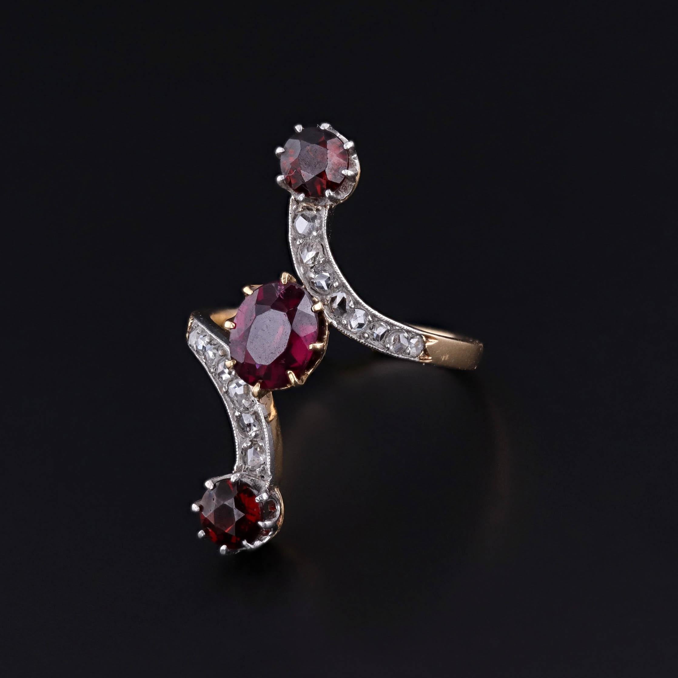 Bague édouardienne en or 18k avec grenat et diamant

Exemple frappant de l'élégance du tournant du siècle, cette bague ancienne datant de 1910 présente un grenat rhodolite ovale central et deux grenats pyrope ronds accentués par des diamants roses