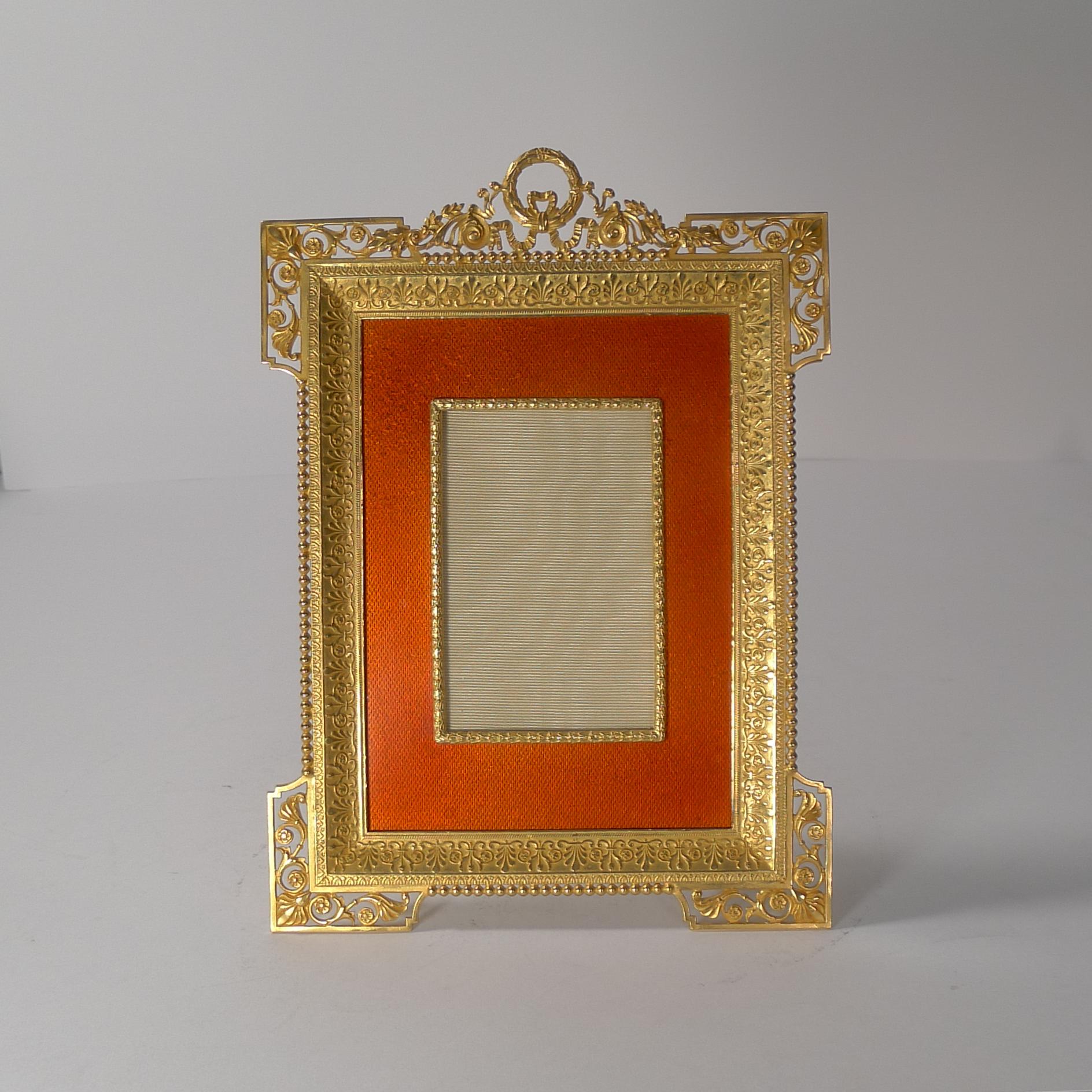 A rare and highly decorative French photograph frame made from bronze smothered in gold, beautifully restored to it's former glory.

Clearly what makes this outstanding is the rich orange coloured enamel panel without damage.

Overall