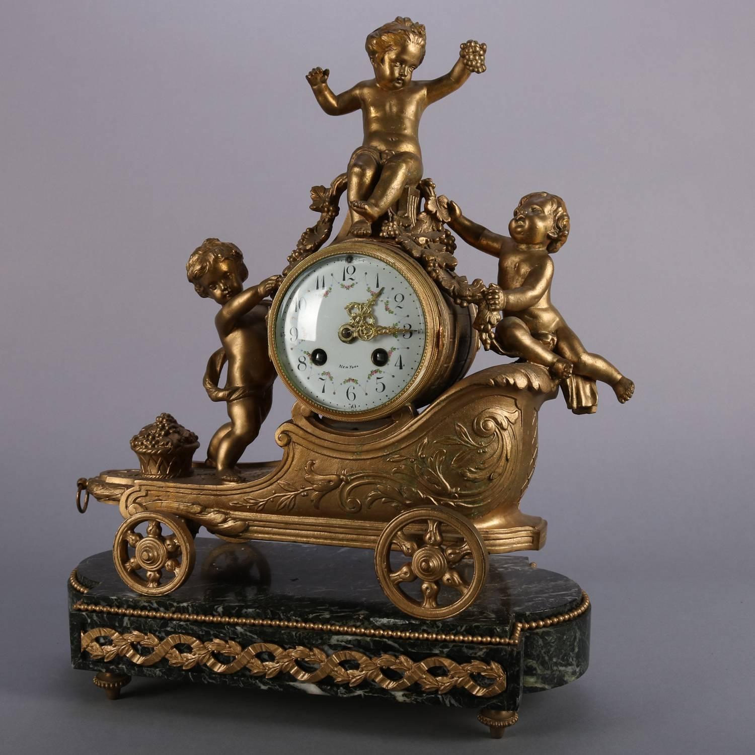 Antique French gilt metal figural mantel clock by S.H. Paris features cherubs with barrel form clock and chariot on marble base, hand painted floral decorated face has Arabic numerals and signed 