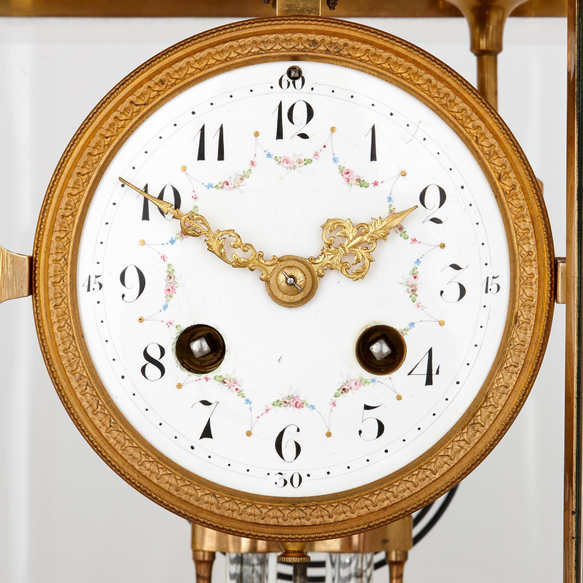 This beautiful three-piece clock set is designed in a French neoclassical style, popular in 19th century decorative arts. The set has been crafted from clear, cut glass and fine gilt bronze. 

The set consists of a central clock, accompanied by