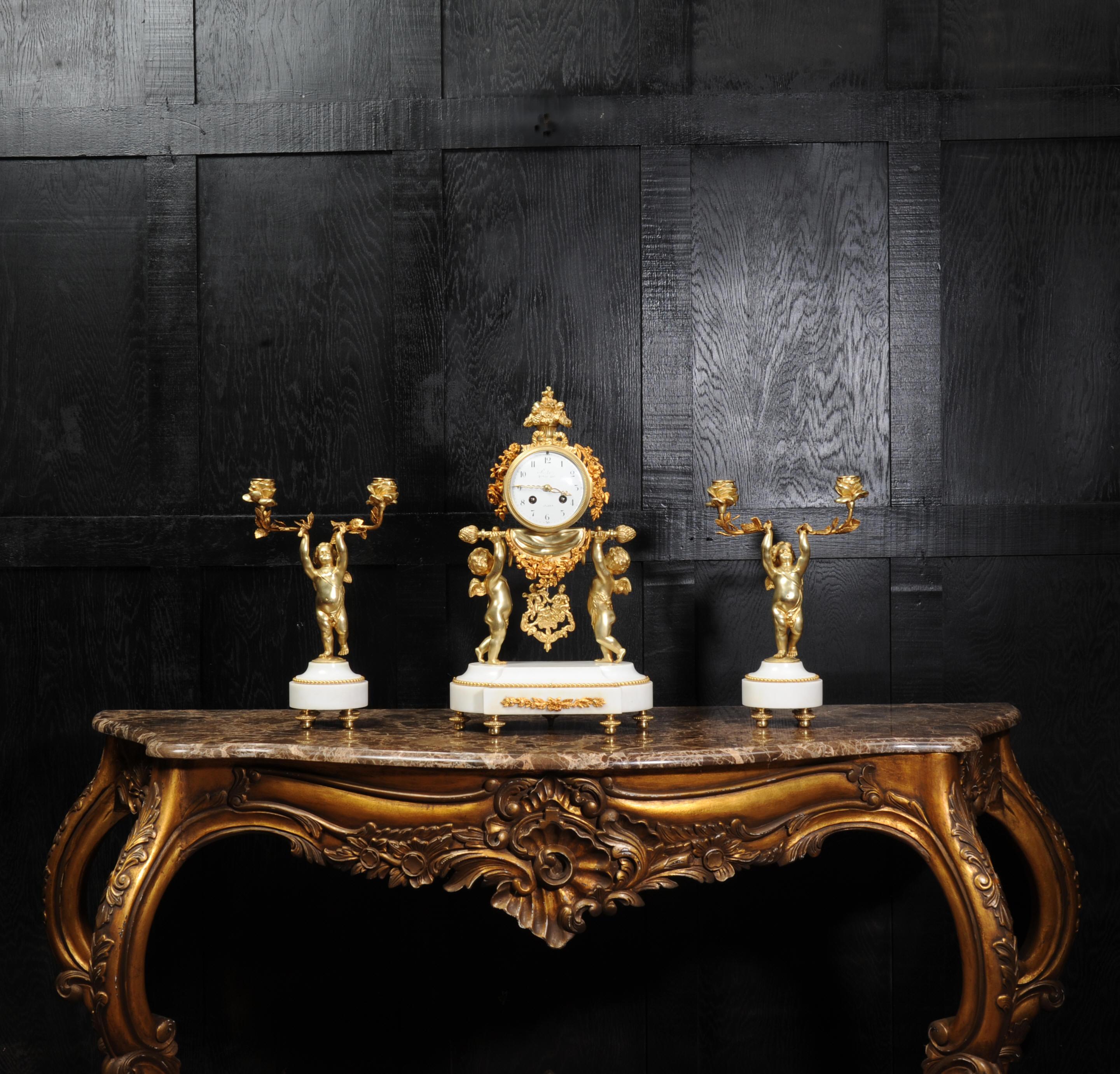 A beautiful original antique French clock set, Louis XVI style, circa 1880. It features charming figures of cherubs, finely modelled in gilt bronze. Two carrying the clock aloft with the pendulum swinging gently below while two cherubs follow
