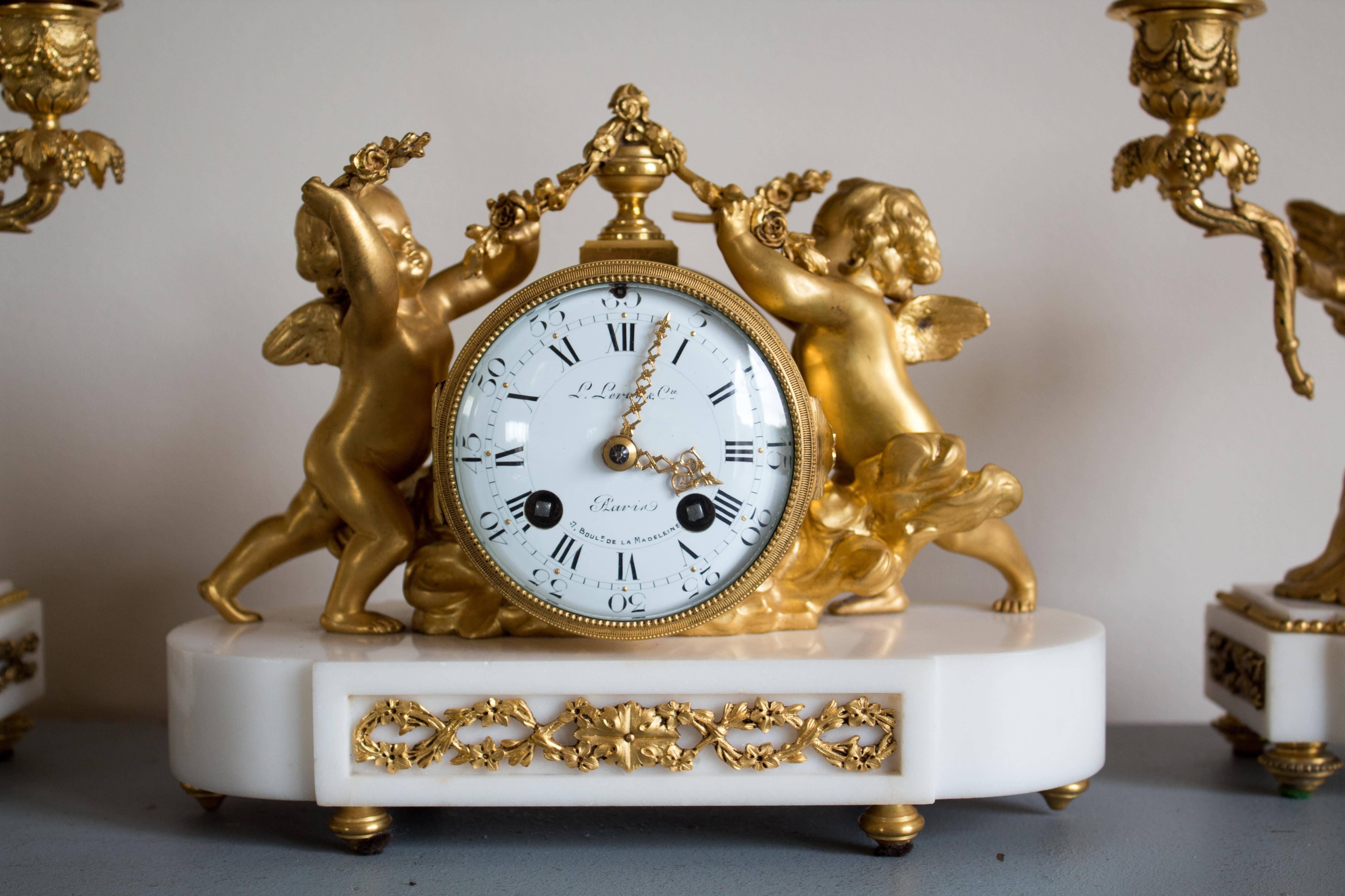 Delightful Louis XVI style set that was crafted by the famous L.Leroy & Cie founded first mid-18th century.
White marble base resting on bun feet, gilt bronze clock with white enameled dial flanked by putti with floral guirlands.
Pair of