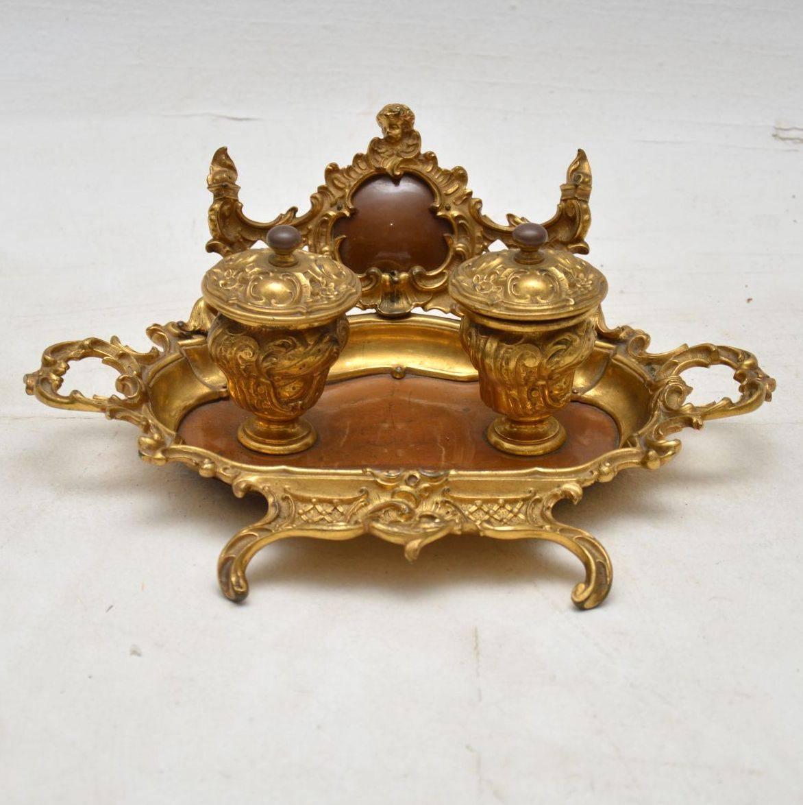 This French antique gilt bronze and polished wood inkwell stand has beautiful decoration all over and has some lovely features. Please enlarge all the images to see all the fine details. I would date this piece to around the 1860s-1880s period and