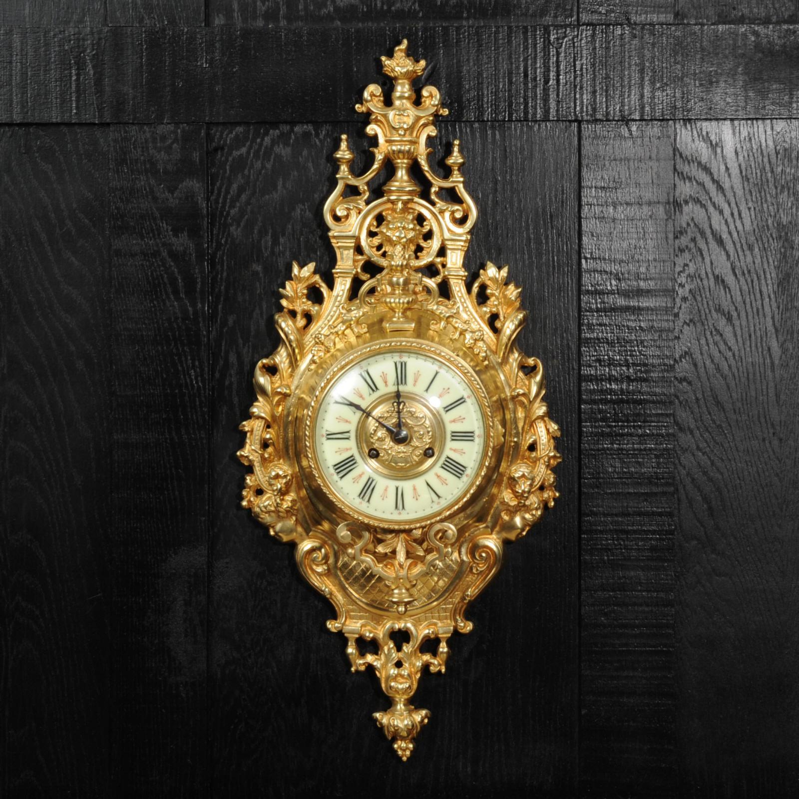 A stunning original antique French cartel wall clock by the famous maker Japy Frères. It is beautifully modelled in gilt bronze in the Baroque style, with scrolling acanthus. Above the dial is a stylised lions mask with an urn above with a flame