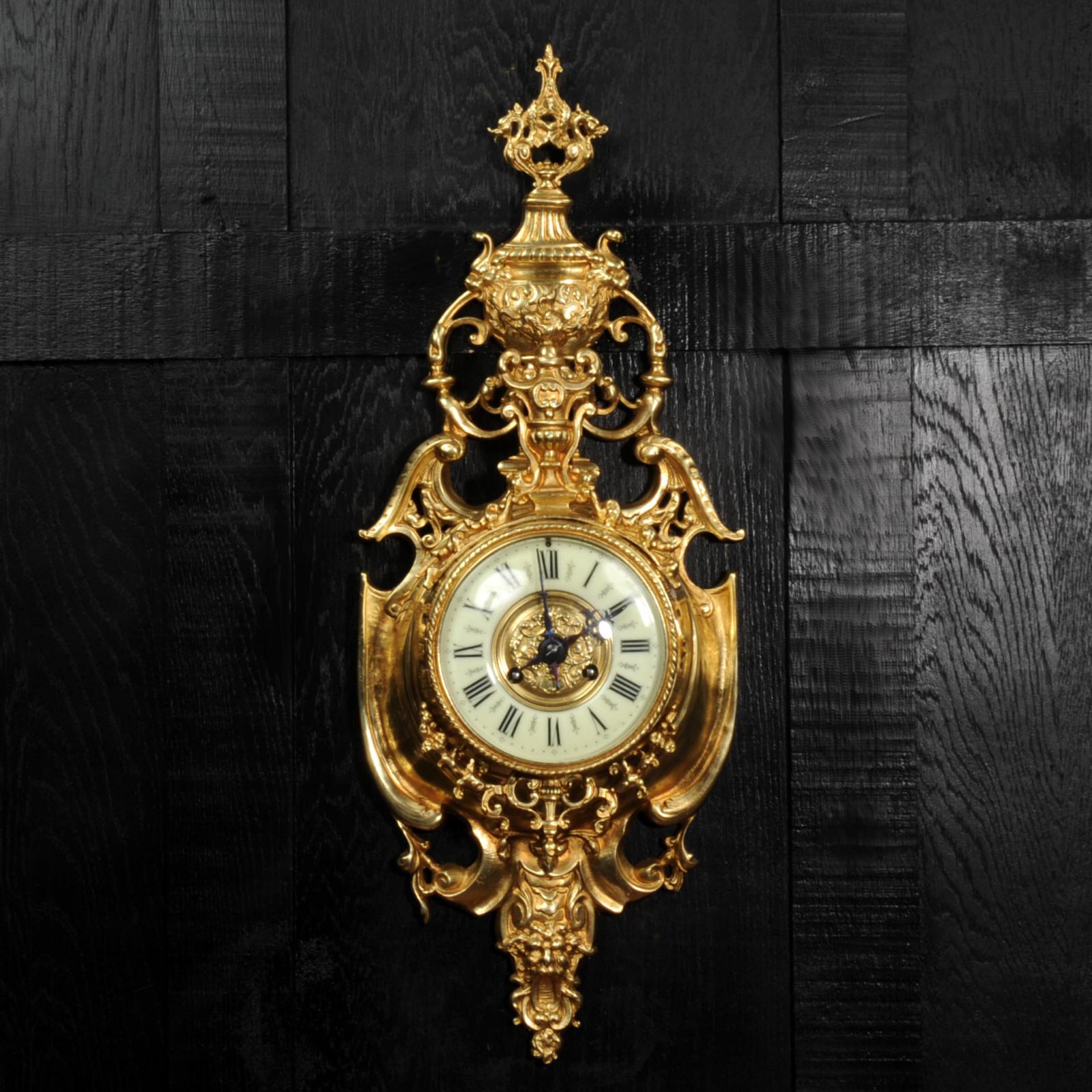 Une superbe horloge murale de cartel française ancienne et originale de Vincenti et Cie. Elle est magnifiquement modelée en bronze doré dans le style baroque, en forme de bouclier avec un fronton en col de cygne, un masque grotesque sous le cadran.