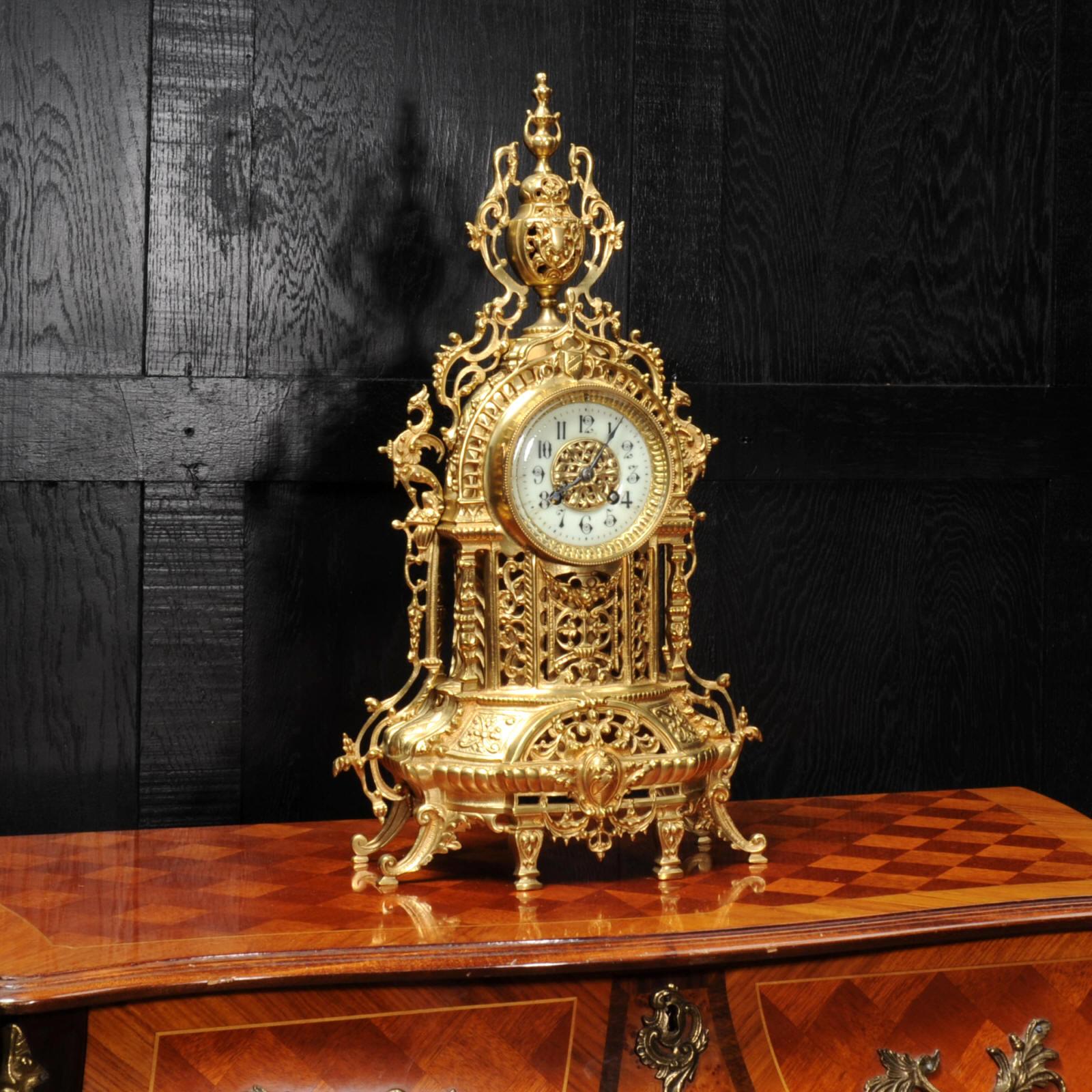 A very pretty original antique French clock, beautifully made from gilded bronze in the Baroque style in around 1880. The case is architecturally modelled and decorated with mythical creatures and profuse flowing foliage. The front of the case is