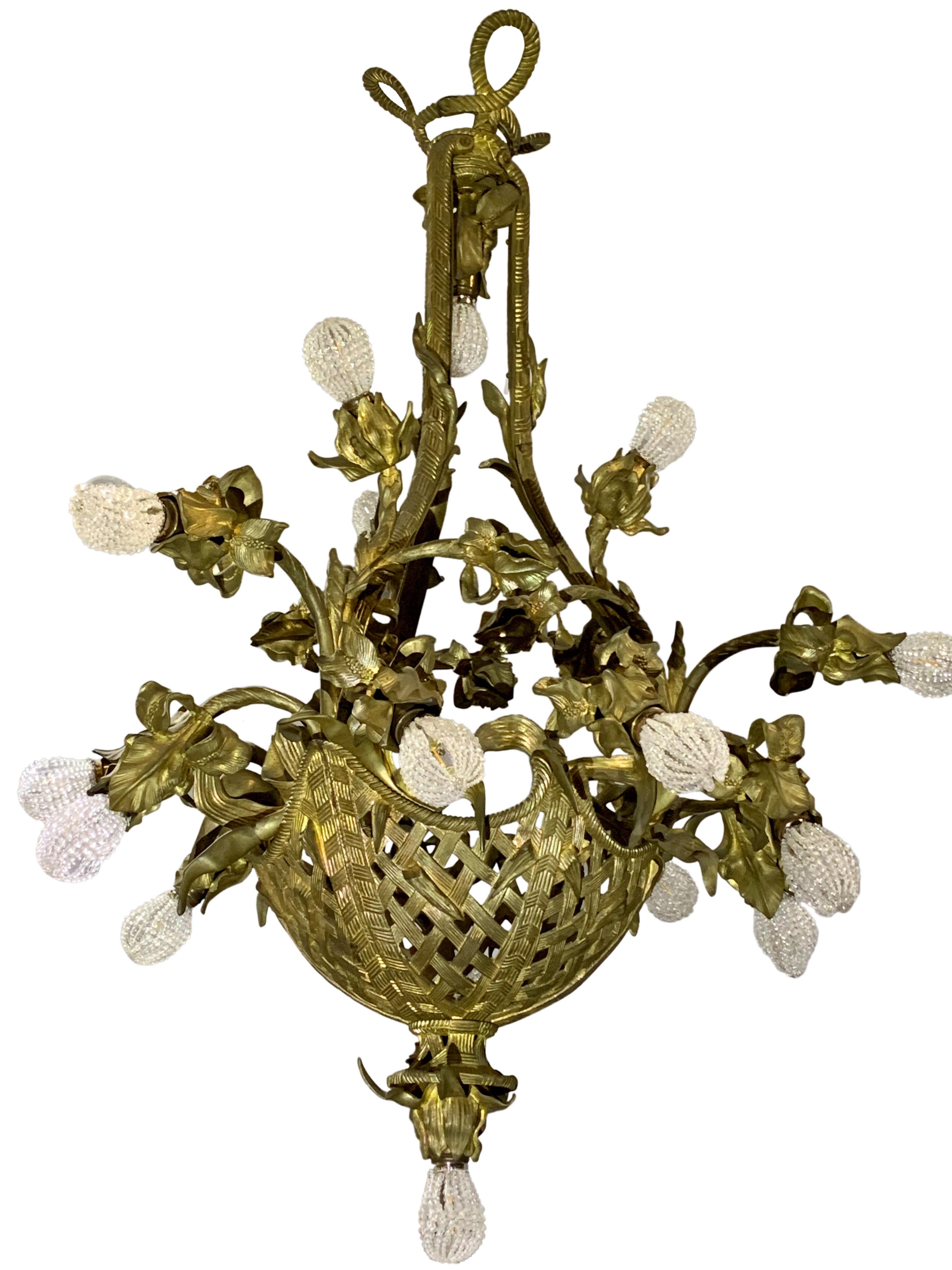 A large French gilt bronze neoclassical style 17-light chandelier in a form of reticulated basket of flowers mounted with total of 23 arms in the form of tulips,

circa 1900.

Measures: Height 46