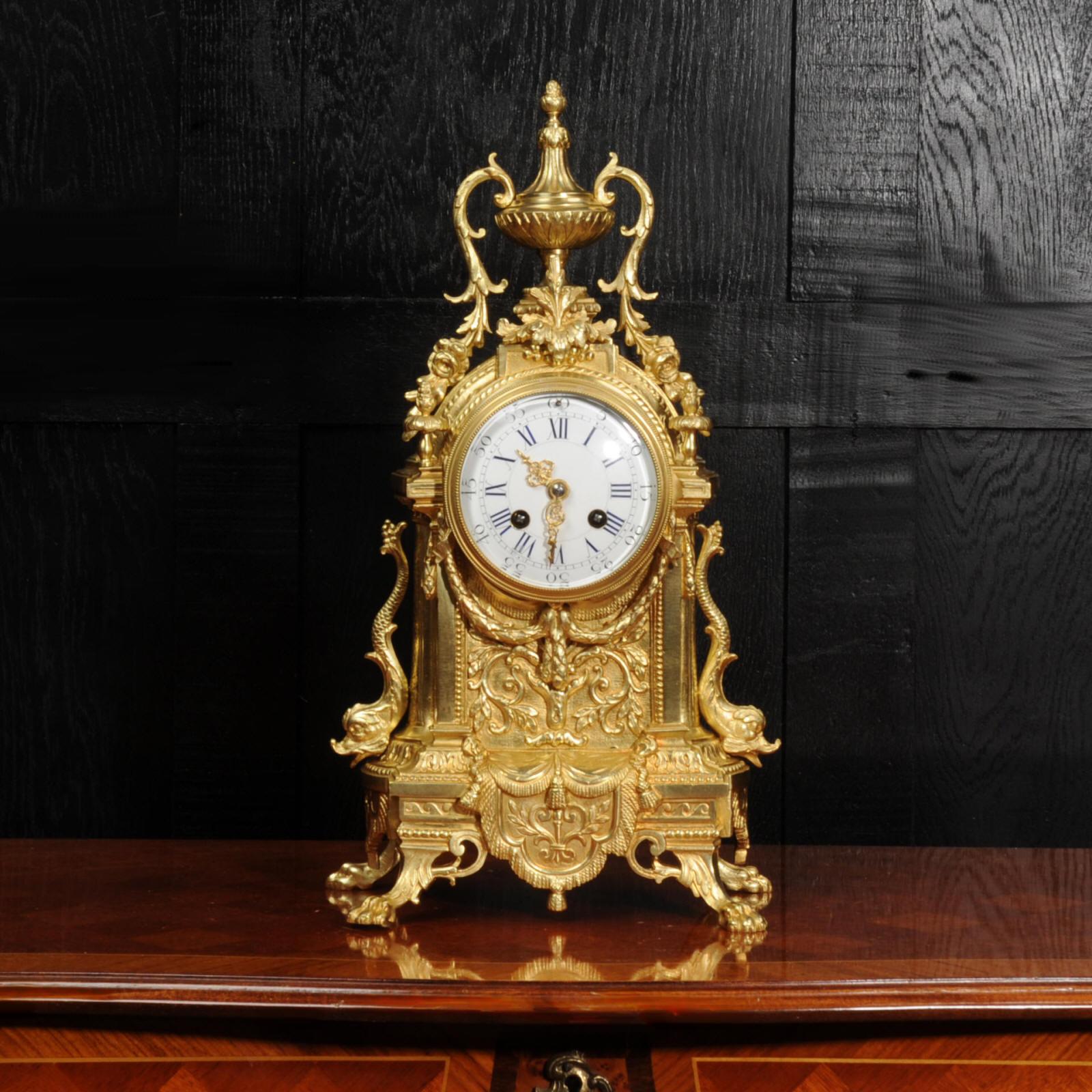 A beautiful original gilt bronze antique French clock by the renown maker Achille Brocot, circa 1880. It is of Baroque design with scrolling, trailing foliage, hairy paw feet and the clock flanked by charming figures of dolphins.

The dial is