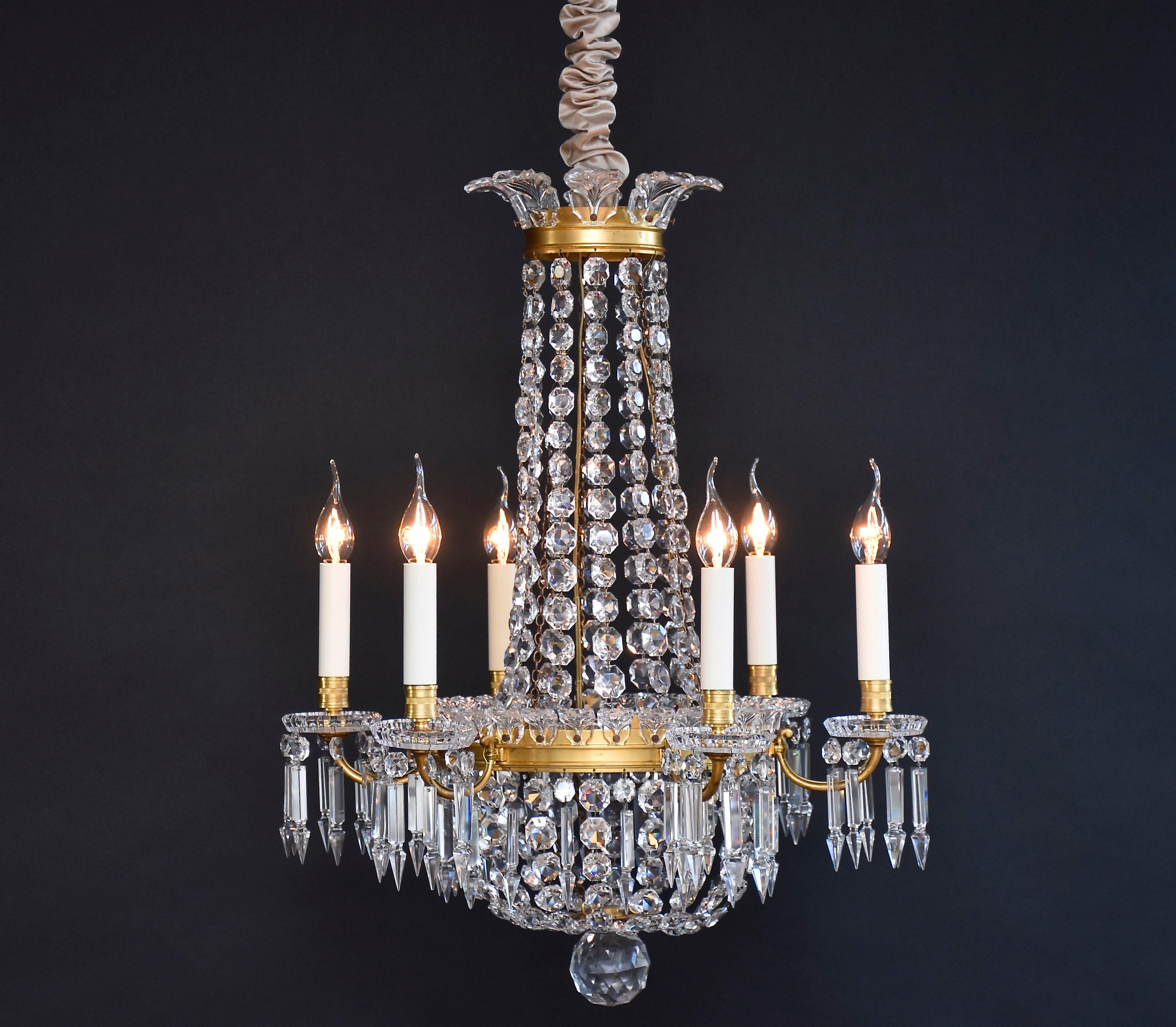 A beautiful French gilt bronze Baccarat chandelier. 
With 6 candle arms around the chandelier.
Decorated with strings of faceted Baccarat octagons and drops.
The crown and central ring decorated with mounted acanthus leaves.
Below the chandelier