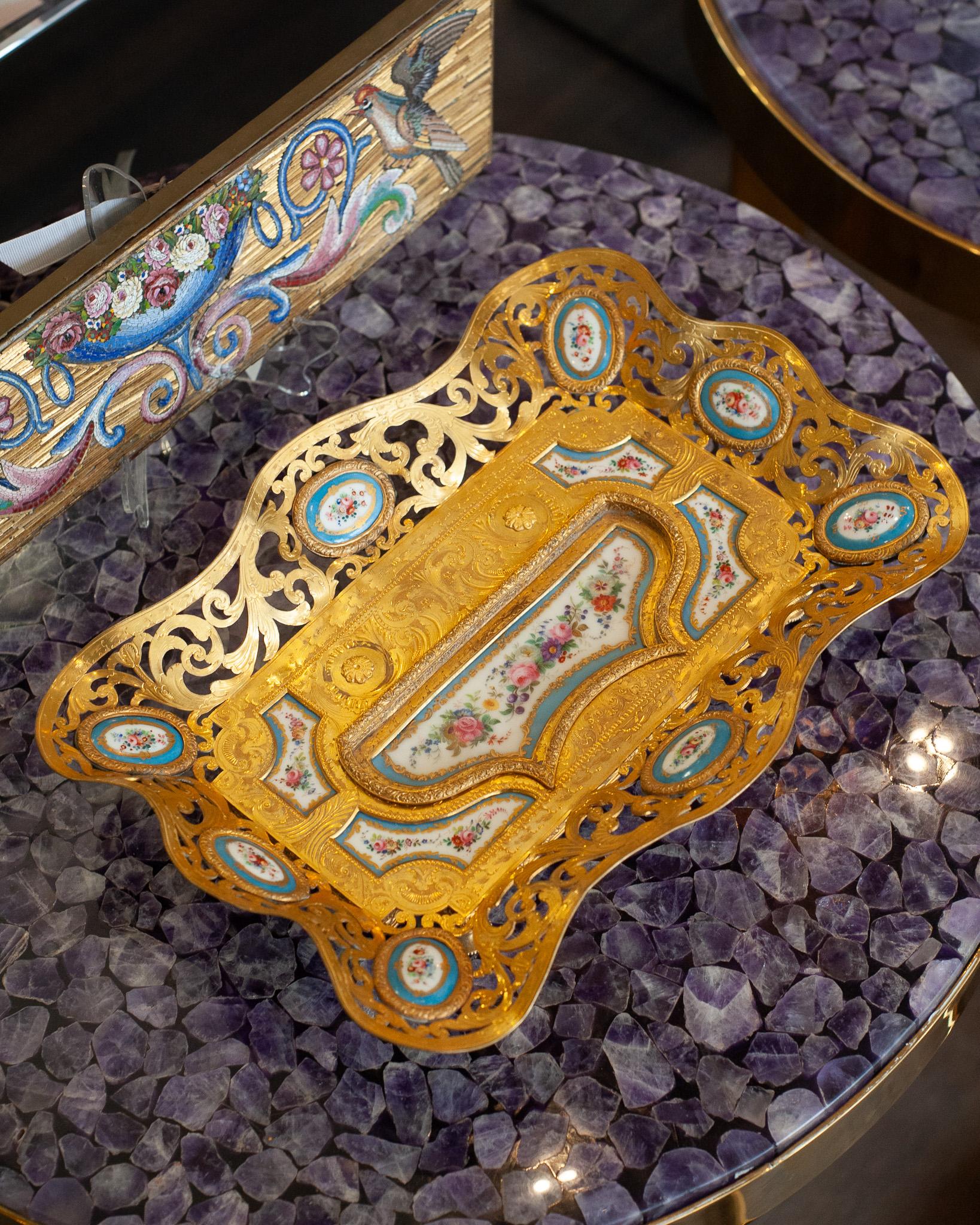 A stunning French gilt bronze table inkwell tray or desk tray, adorned with exquisite Sèvres soft paste porcelain inset plaques. These hand-painted plaques showcase exceptional craftsmanship and classic artistry of Sèvres and date back to the late