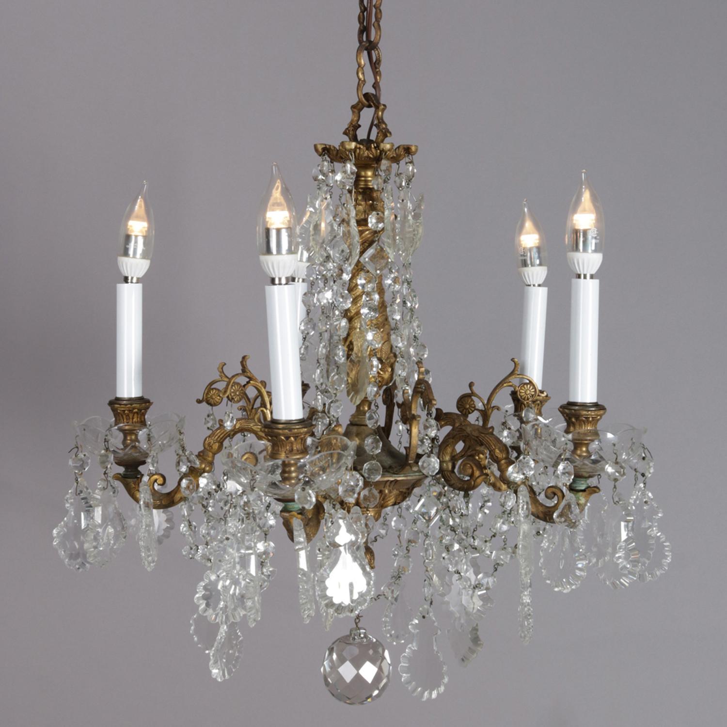 Antique French chandelier features gilt bronze frame with five scroll and foliate form arms terminating in candle lights, strung and cut crystals throughout, circa 1900. 

***DELIVERY NOTICE – Due to COVID-19 we have employed LIMITED-TO-NO-CONTACT
