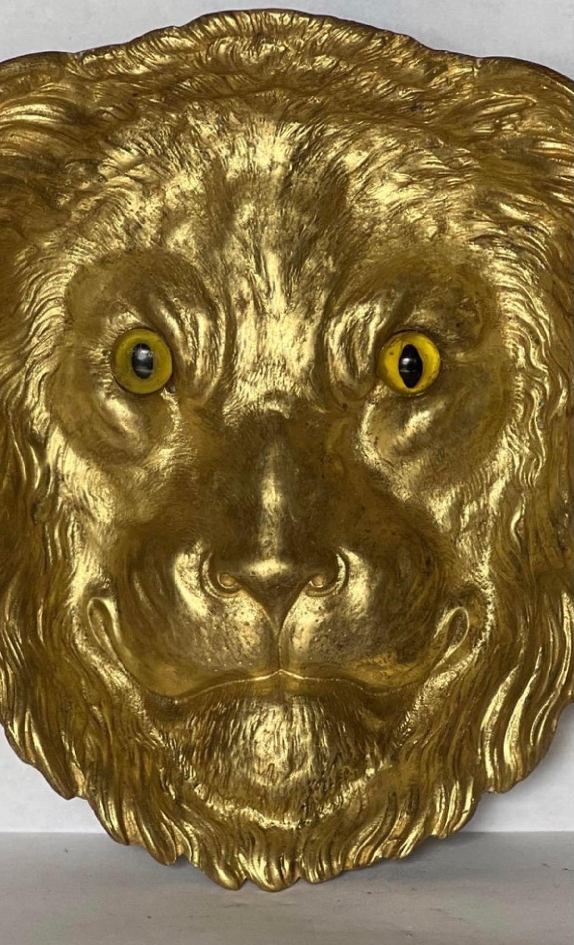 Un très beau et rare cendrier ou attrape-tout français en forme de tête de lion avec des yeux en verre. Pièce très unique avec une certaine usure et une perte mineure au verso - non observée au repos.