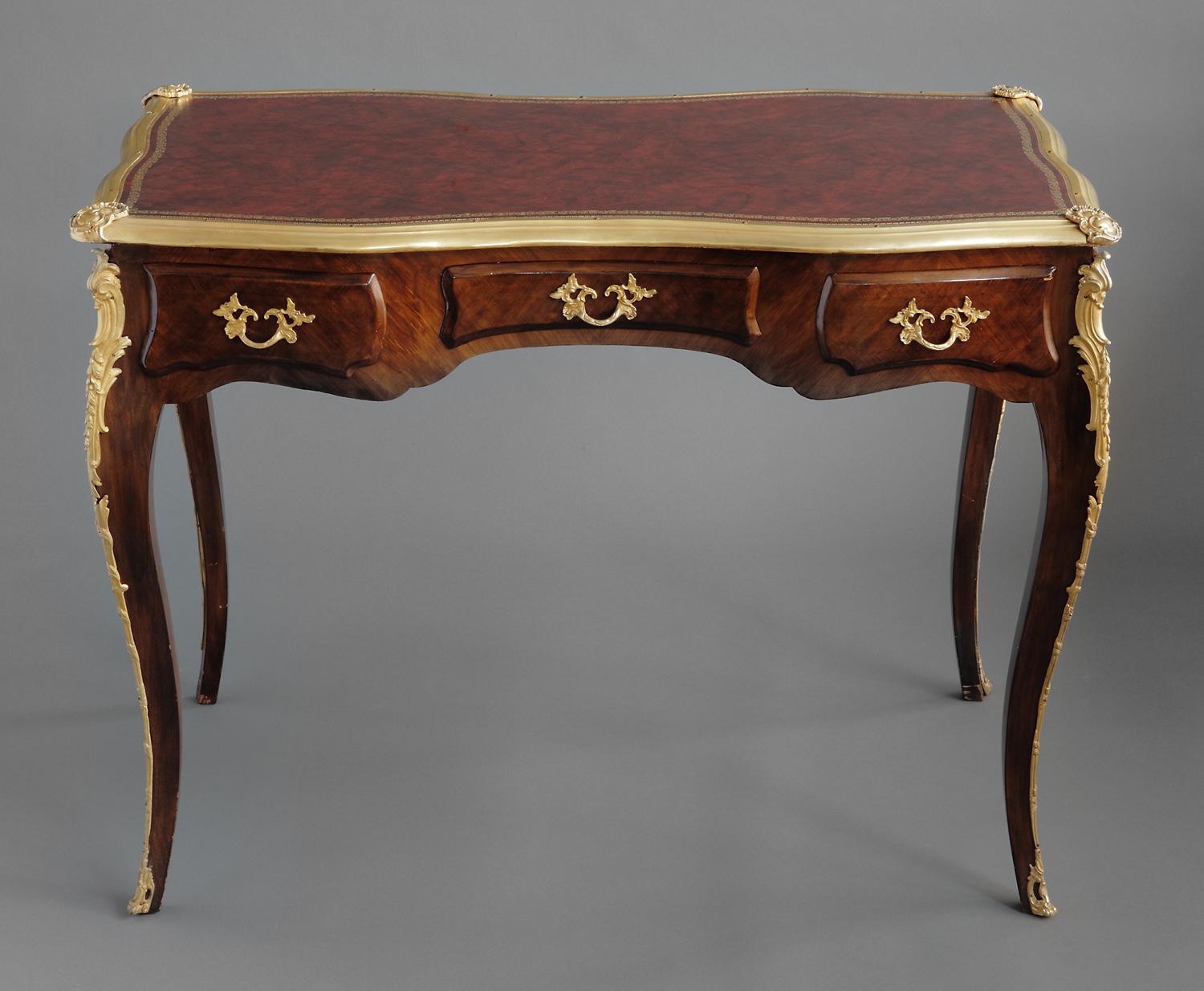 A fine 19th century French Louis XV style gilt bronze-mounted wood leather top ladies desk. The writing table stands on four cabriole legs, decorated at the shoulder with gilt bronze mounts and is fitted with three drawers to the frieze and three