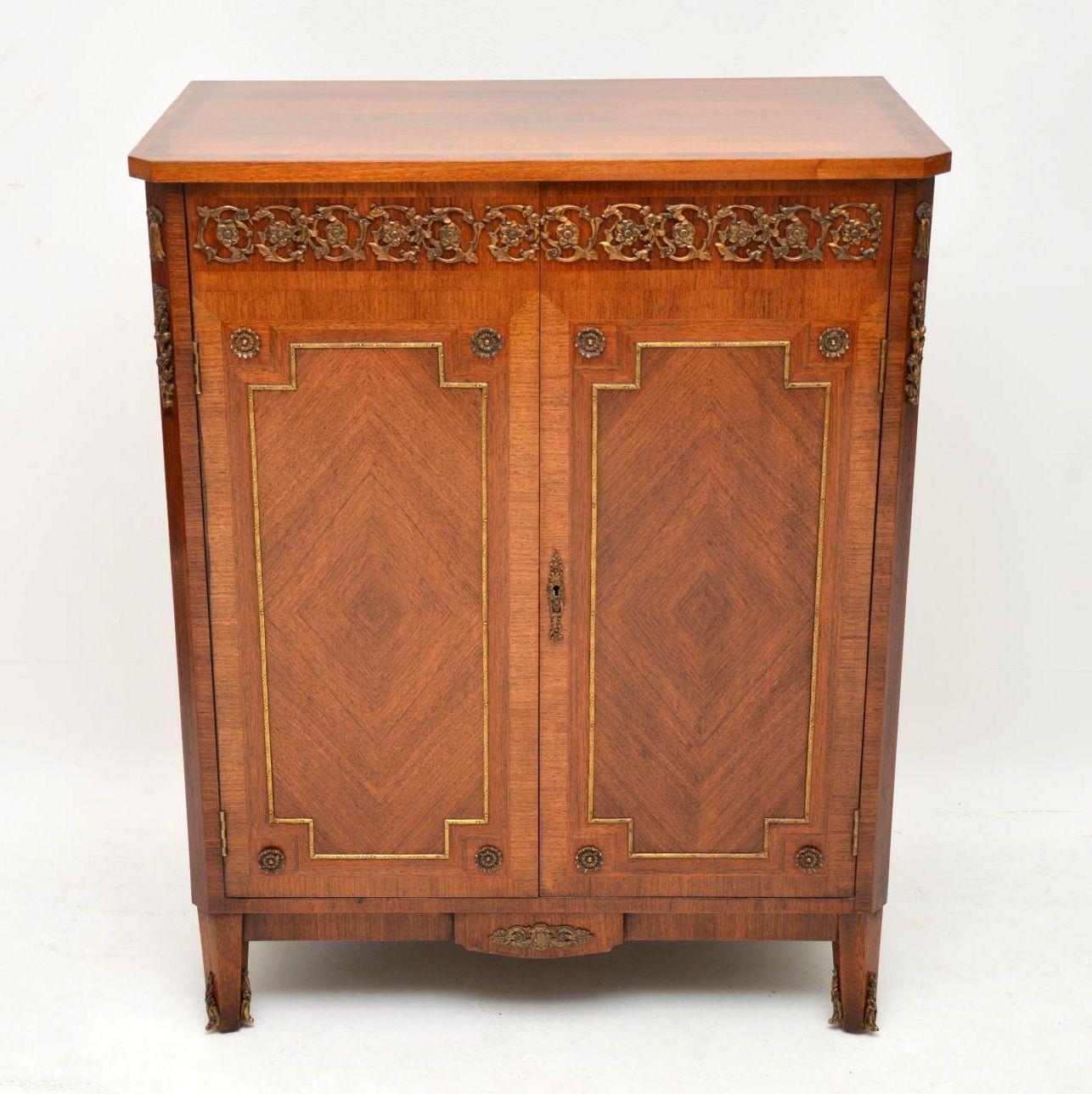 Antique French Kingwood and walnut cabinet in excellent condition, with plenty of storage inside. This cabinet has some fine gilt bronze mounts in various places on the front and canted corners. I would date it to circa 1920s-1930s