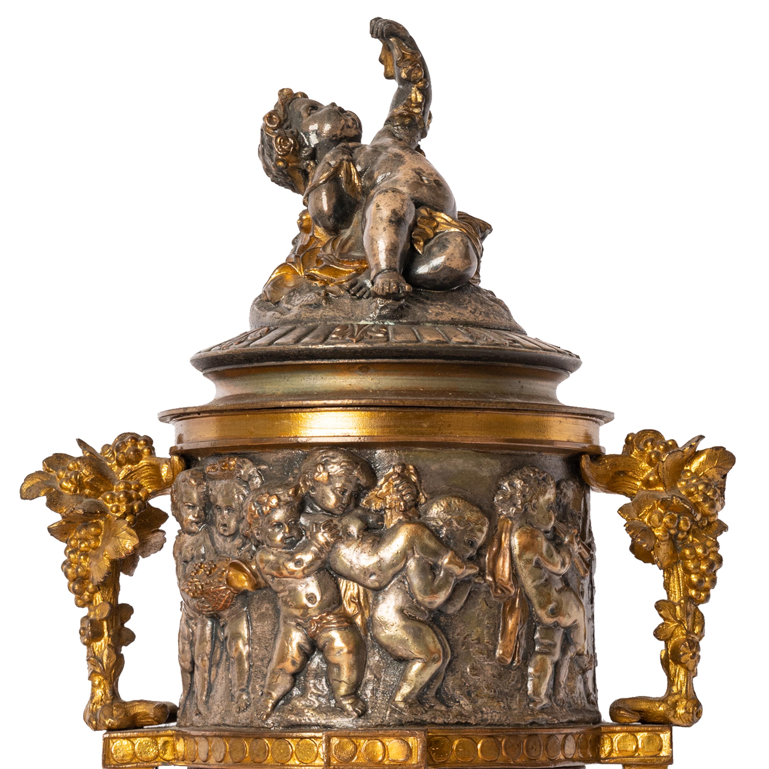 A Fine antique French gilded bronze lidded urn/wine cooler, Napoleon III period, in the style of Claude Michel Clodion, circa 1870.
This very elegant urn is made of patinated bronze with gilded accents, the lid having a reclining putto. The body of