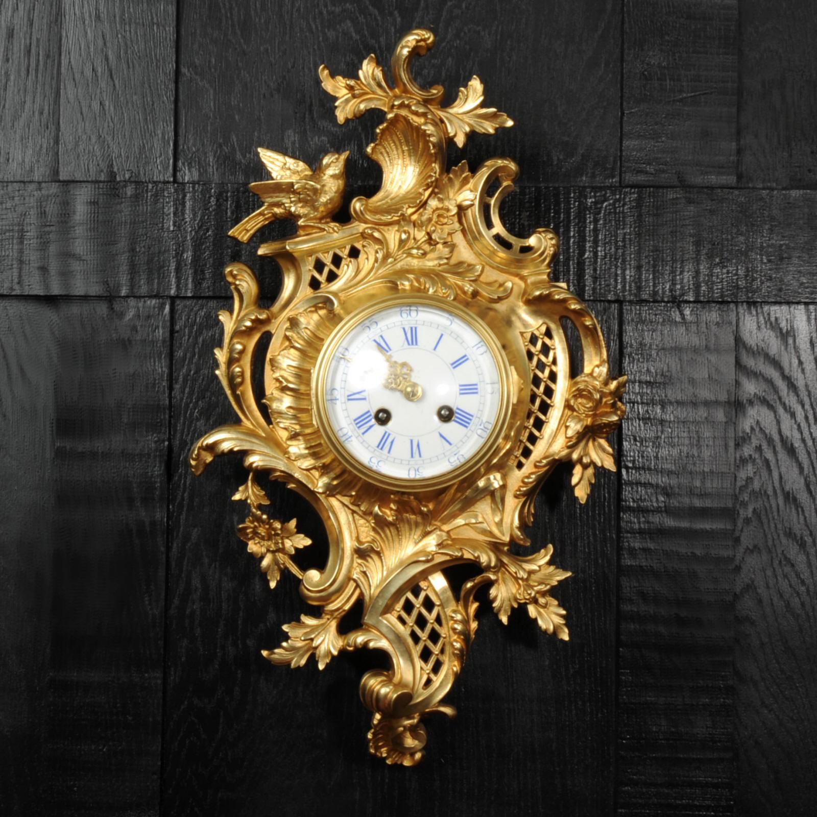 A stunning original antique French gilt bronze Cartel wall clock by Japy Frères. It is beautifully designed in the Rococo style, asymmetrical panels of curving trellis work, covered with flowers and entwined foliage. To the top, a bird gently lands