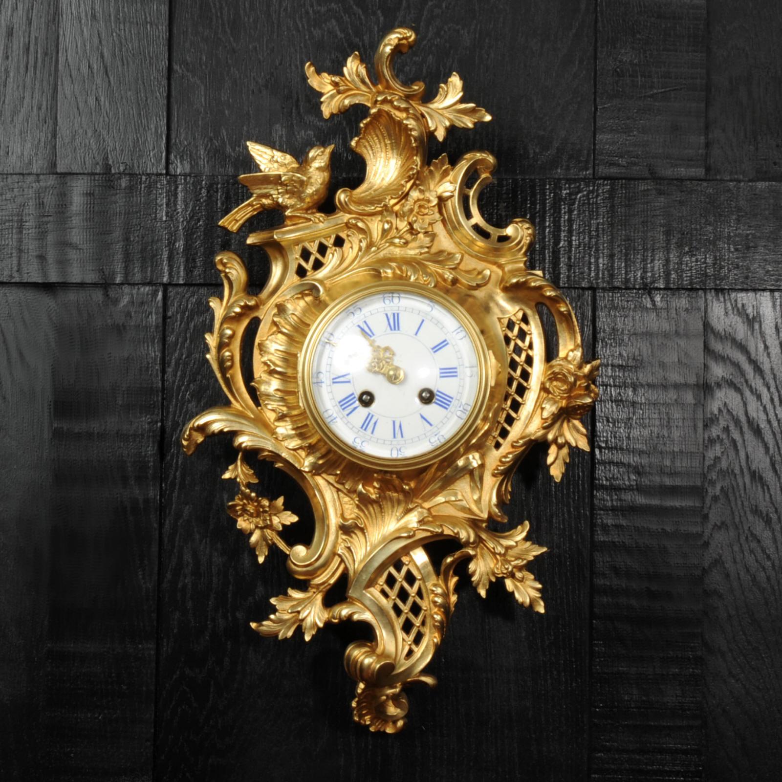 Une superbe horloge murale Cartel en bronze doré de Japy Frères. Il est magnifiquement conçu dans le style rococo, avec des panneaux asymétriques de treillis incurvés, couverts de fleurs et de feuillages entrelacés. En haut, un oiseau se pose