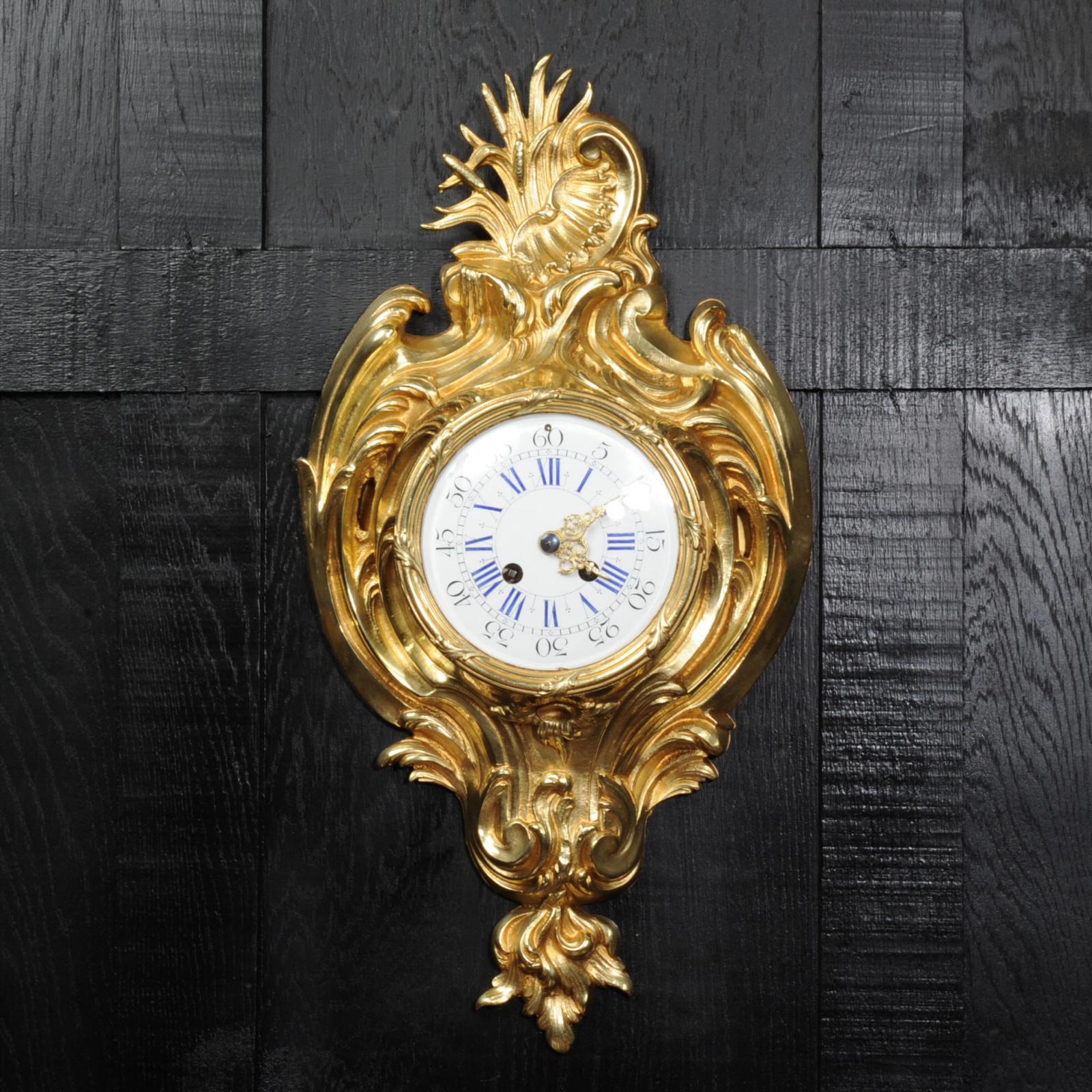 A beautiful original antique French cartel wall clock, circa 1890. It is finely made in gilt bronze in the Rococo style. It is formed of flowing scrolls and acanthus with an elaborate asymmetric C-scroll and shell motif to the top. It is in stunning