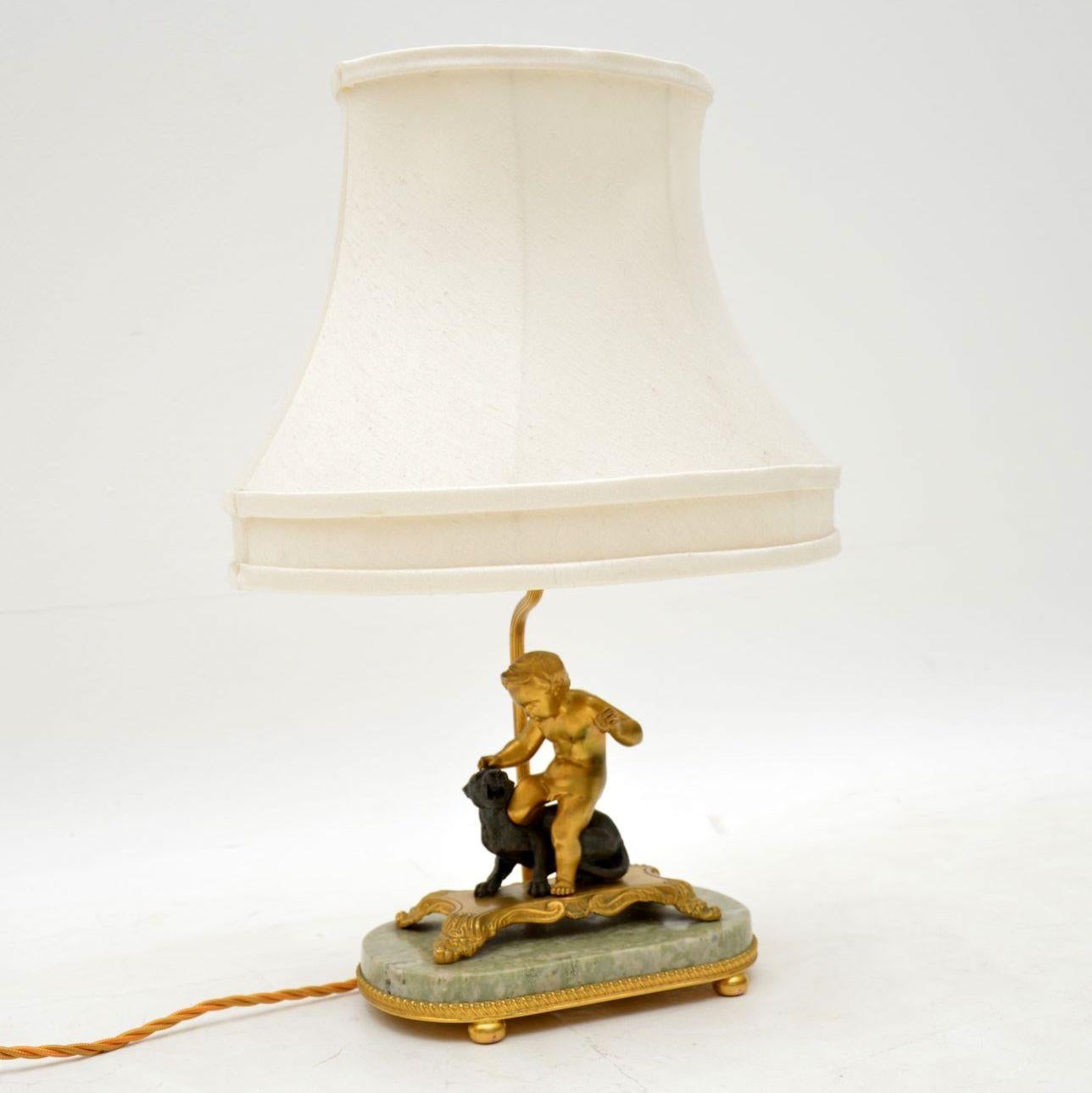 Antique French gilt bronze table lamp in the form of a cherub with a lion (I think), mounted on a marble base with more gilt decoration. This is a very attractive small lamp, which still has the old shade, which to be honest is a bit tatty mainly on