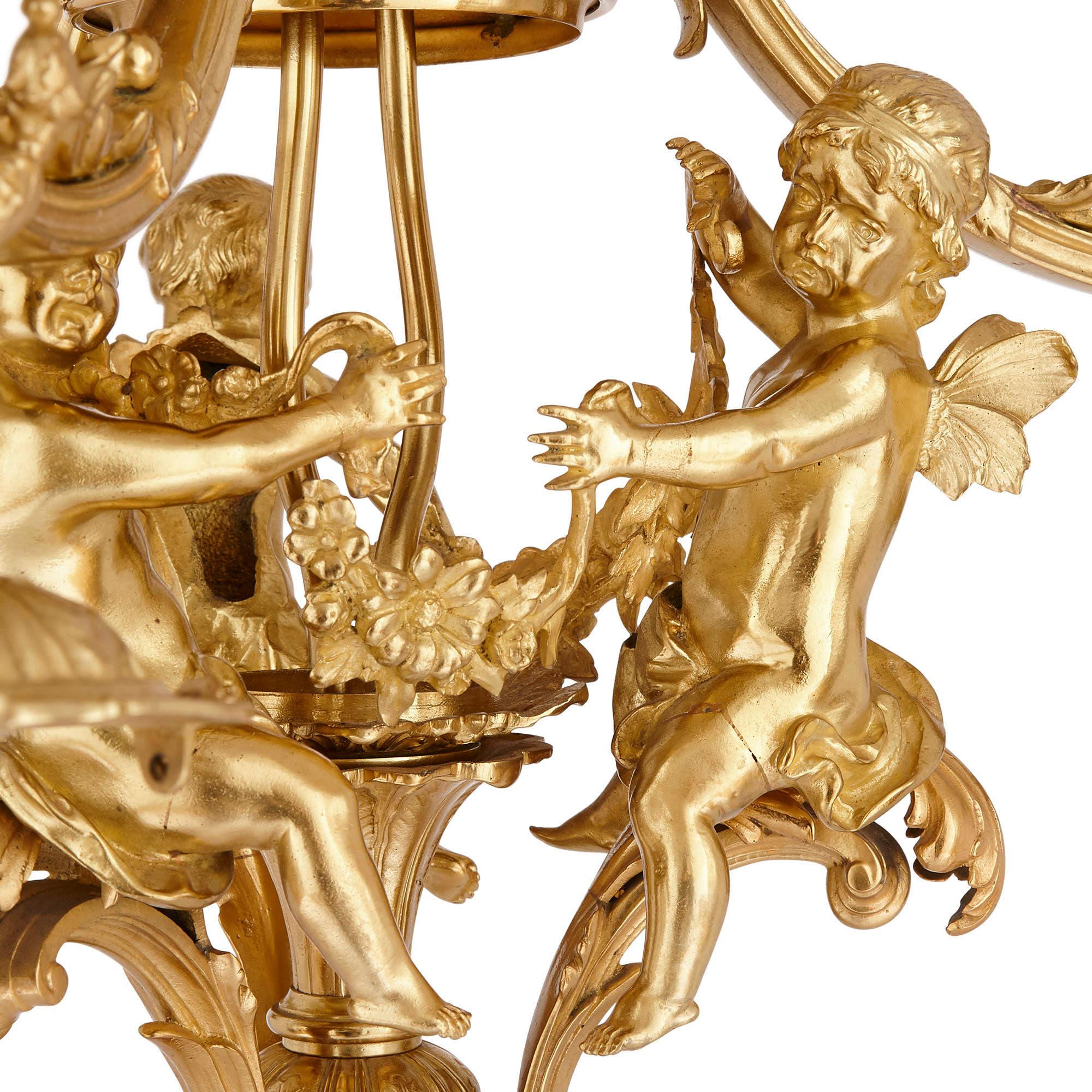 Designed during the sumptuous Belle Époque, this gilt bronze chandelier demonstrates the very best of the period.

The chandelier is supported by a central highly ornate gilt bronze stem. This stem supports the three light branches, each C-scroll