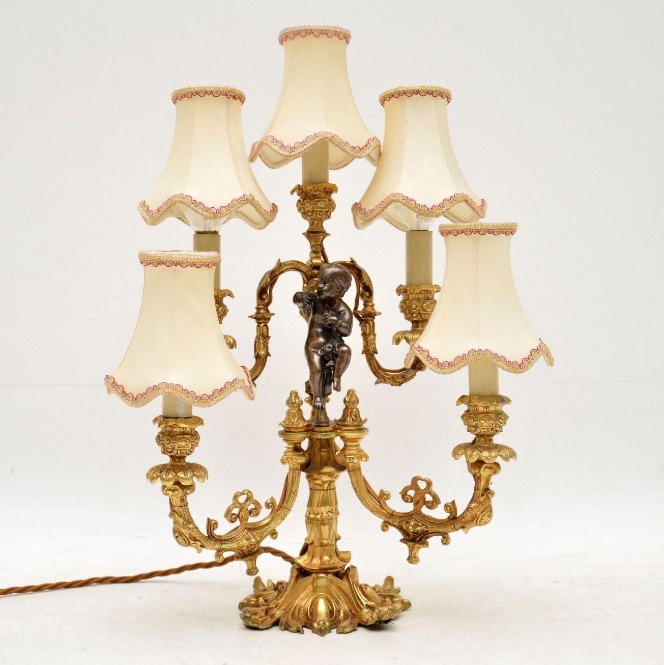 Very ornate antique French gilt metal and bronze candelabra lamp with five arms and lights attached. This lamp has been rewired and has the right shades which can clip onto the bulbs. It’s a matter of choice if you want to use the shades or not &