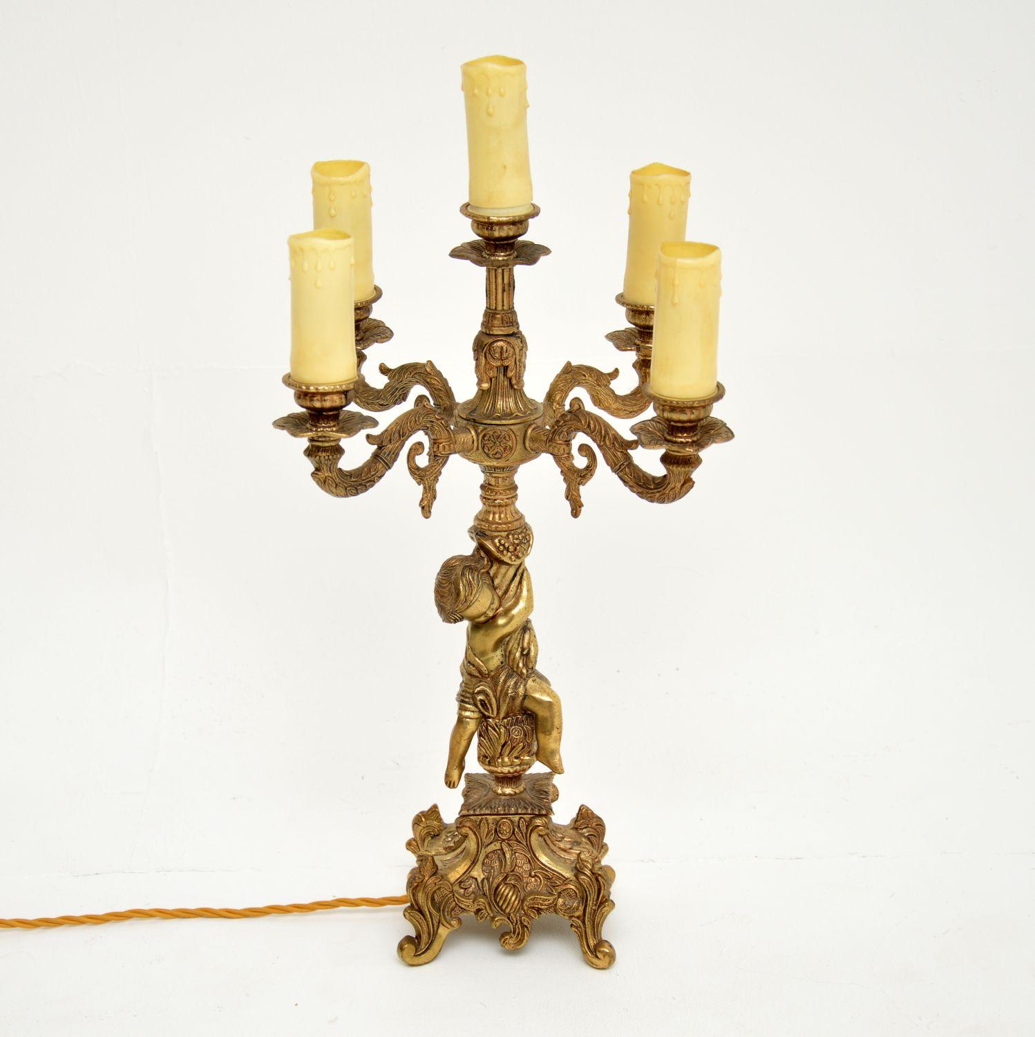 A gorgeous antique French candelabra table lamp in gilt metal. This was made in France, it dates from around the 1920-1930’s.

The quality is lovely, this is cast in wonderful detail and depicts a beautiful cherub supporting the main column. There