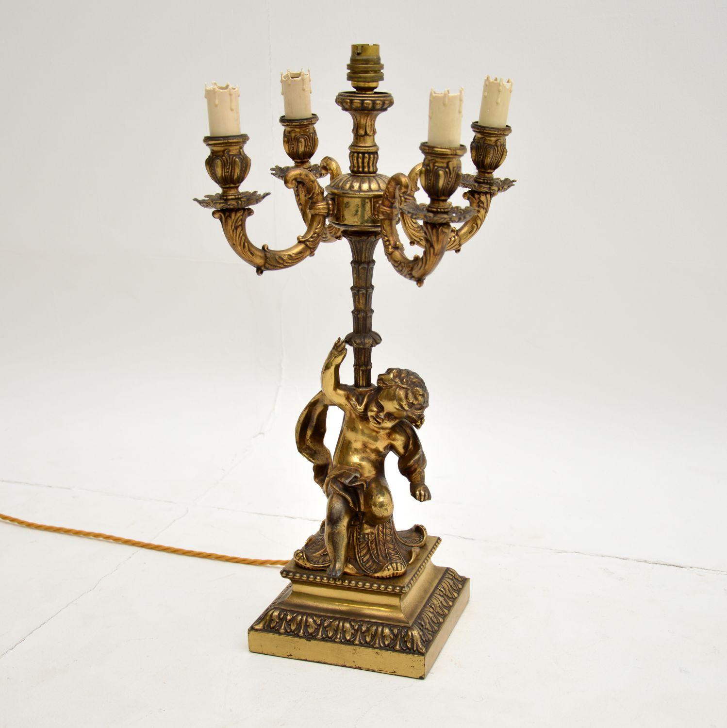 A stunning antique gilt metal table lamp, made in France and dating from the 1910-20 period.

This is of extremely fine quality, with a finely cast and characterful cherub supporting the main column. There are four smaller sockets supported by