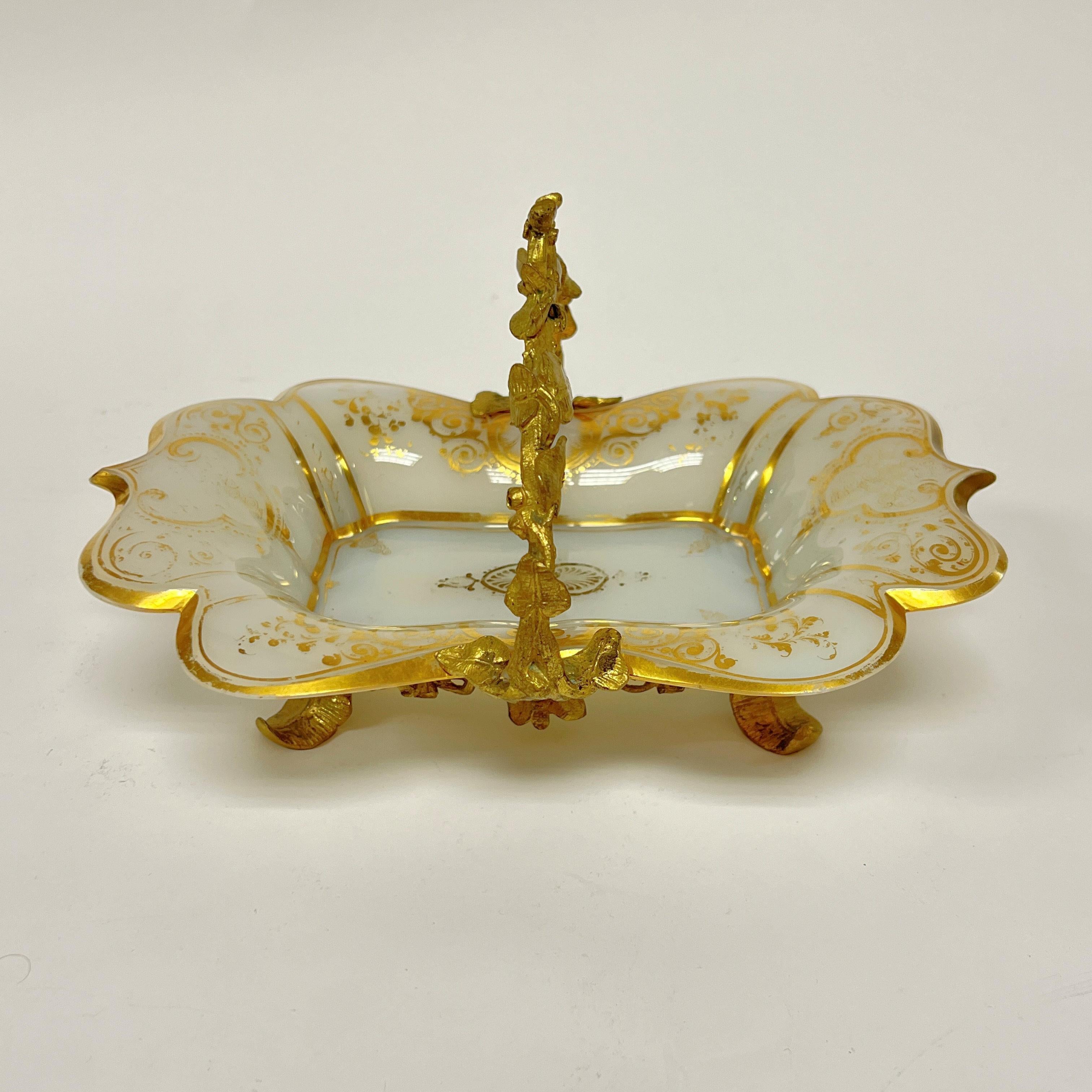 Our lovely antique French opaline glass candy dish with gilt decorations and gilt bronze mounts dates from late 19th century and is in good condition.  Some rubbing wear to the gilding and an old professional restoration to chip loss at one end. 