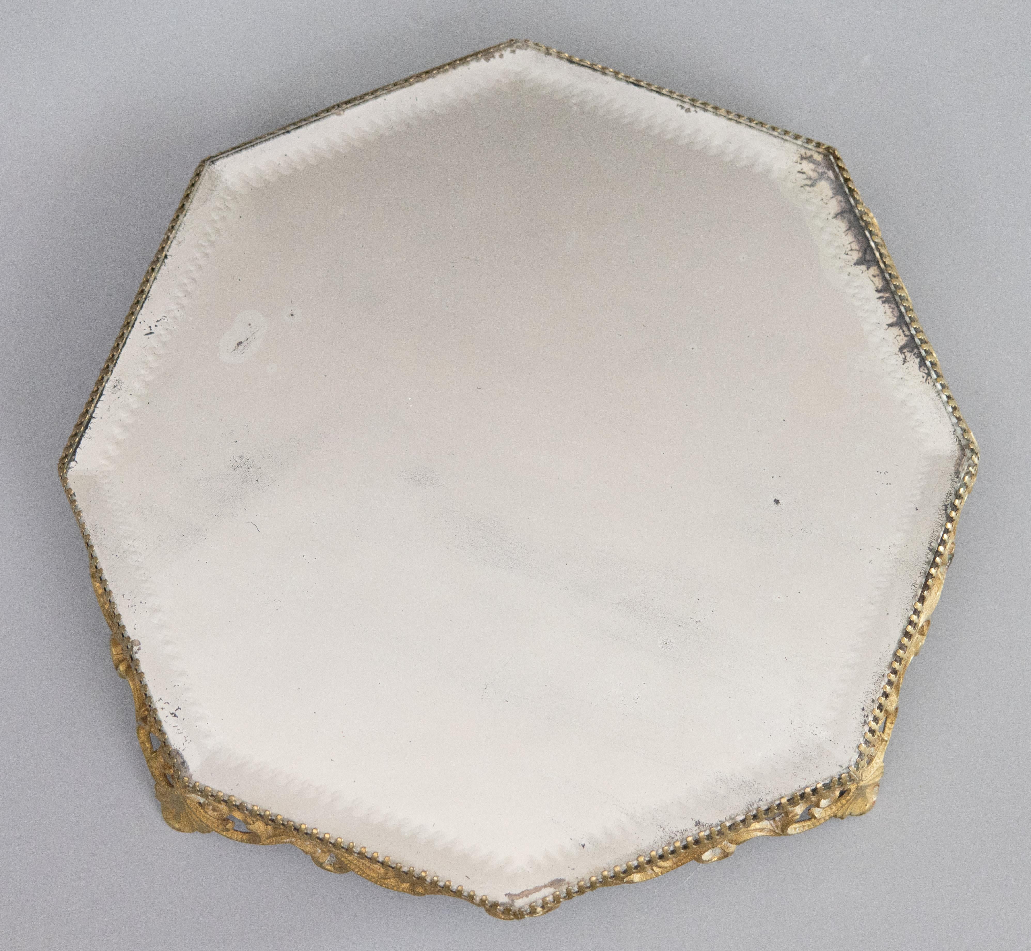 Preciosa meseta de espejo francesa antigua de latón dorado u ormolu, hacia 1920. Esta hermosa meseta tiene volutas ornamentadas en una preciosa pátina dorada y un raro diseño octogonal. Conserva el cristal de espejo biselado original. Quedaría